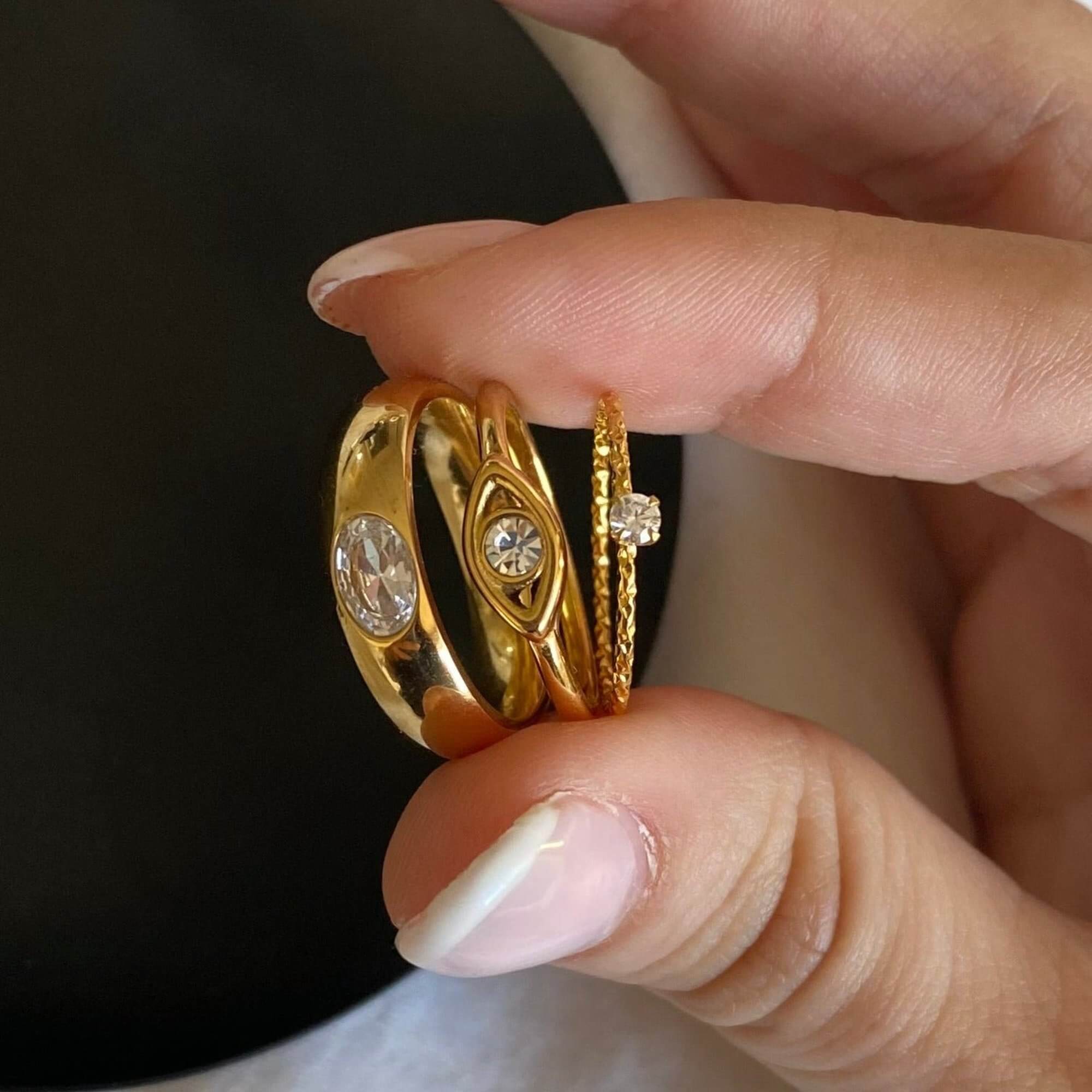 Stacked view of the KimmyR oval diamond cigar band ring by Kampy Designs, layered with other rings for a bold and stylish statement.