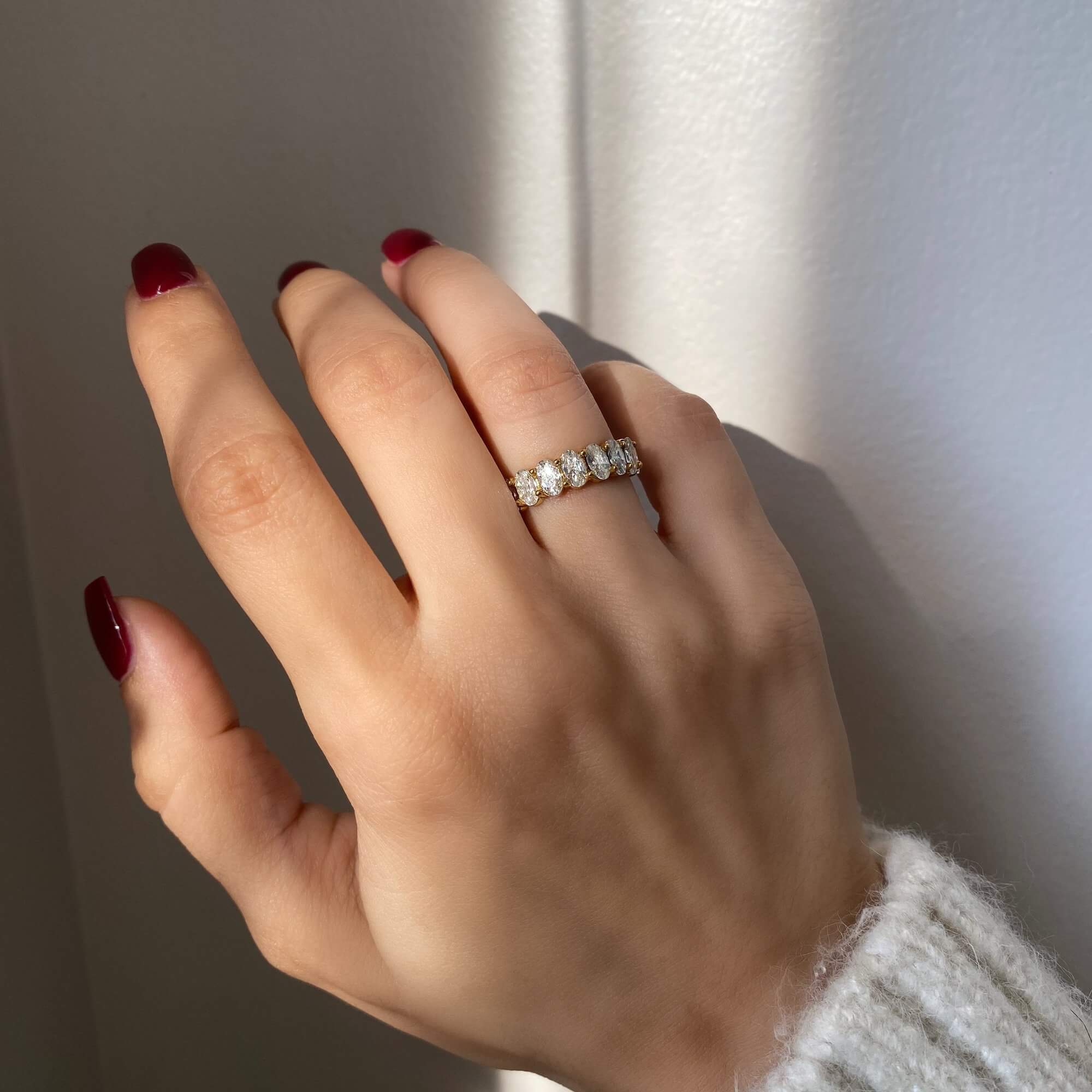 The KastielR oval diamond eternity ring by Kampy Designs, beautifully worn to highlight its continuous row of sparkling oval-cut diamonds.