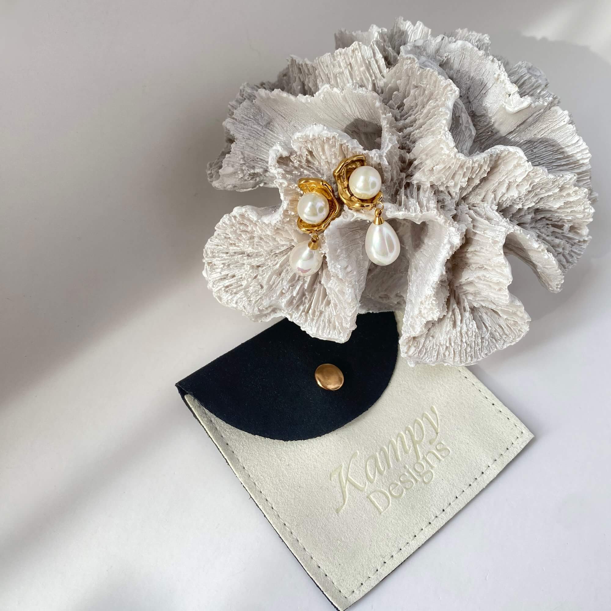 Aesthetic composition of KearyE oyster pearl dangle earrings by Kampy Designs, styled with neutral textures for an elegant marine vibe.