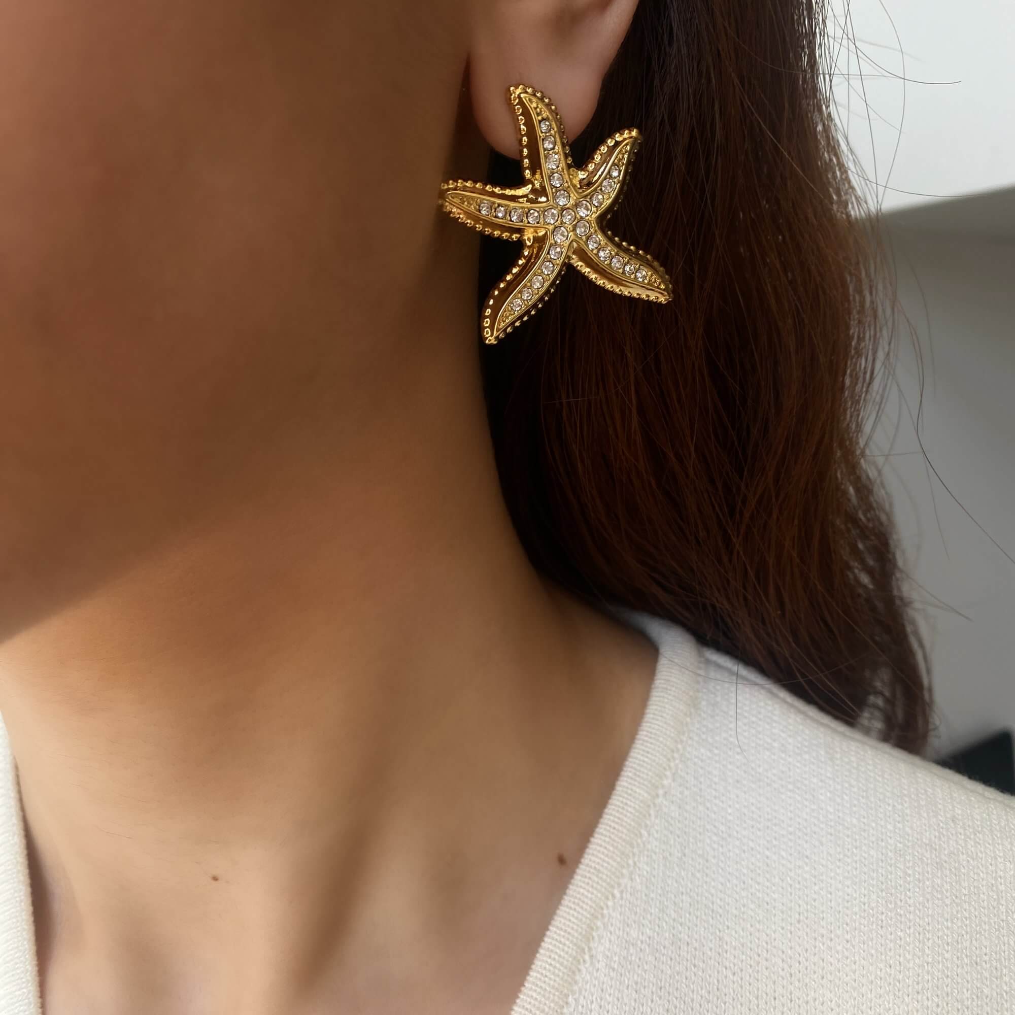 Angled view of the KariyaE pavé starfish statement earrings by Kampy Designs, worn on model’s ear to show off the textured starfish silhouette and dazzling crystals.