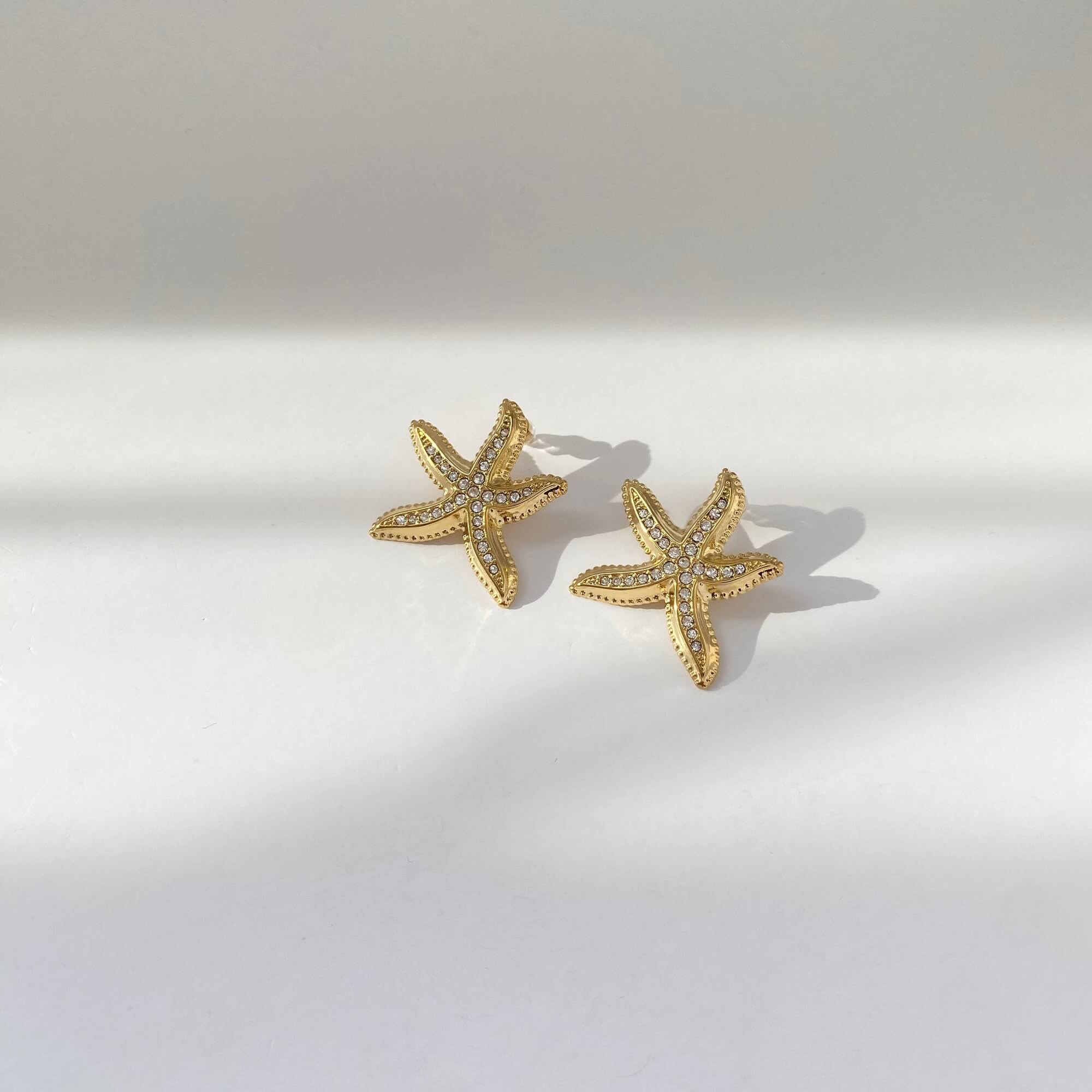 Angled view of the KariyaE pavé starfish earrings by Kampy Designs, revealing the texture, shape, and reflective pavé finish.