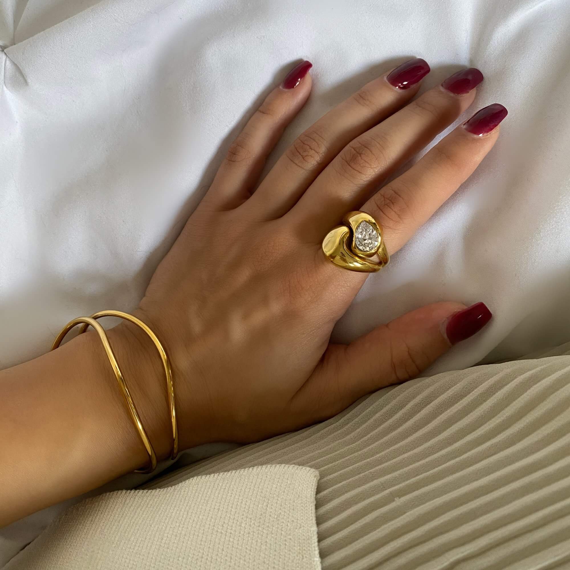 Angled view of the KampyR pear diamond dome ring by Kampy Designs, capturing its polished dome structure and sparkling pear-cut diamond.