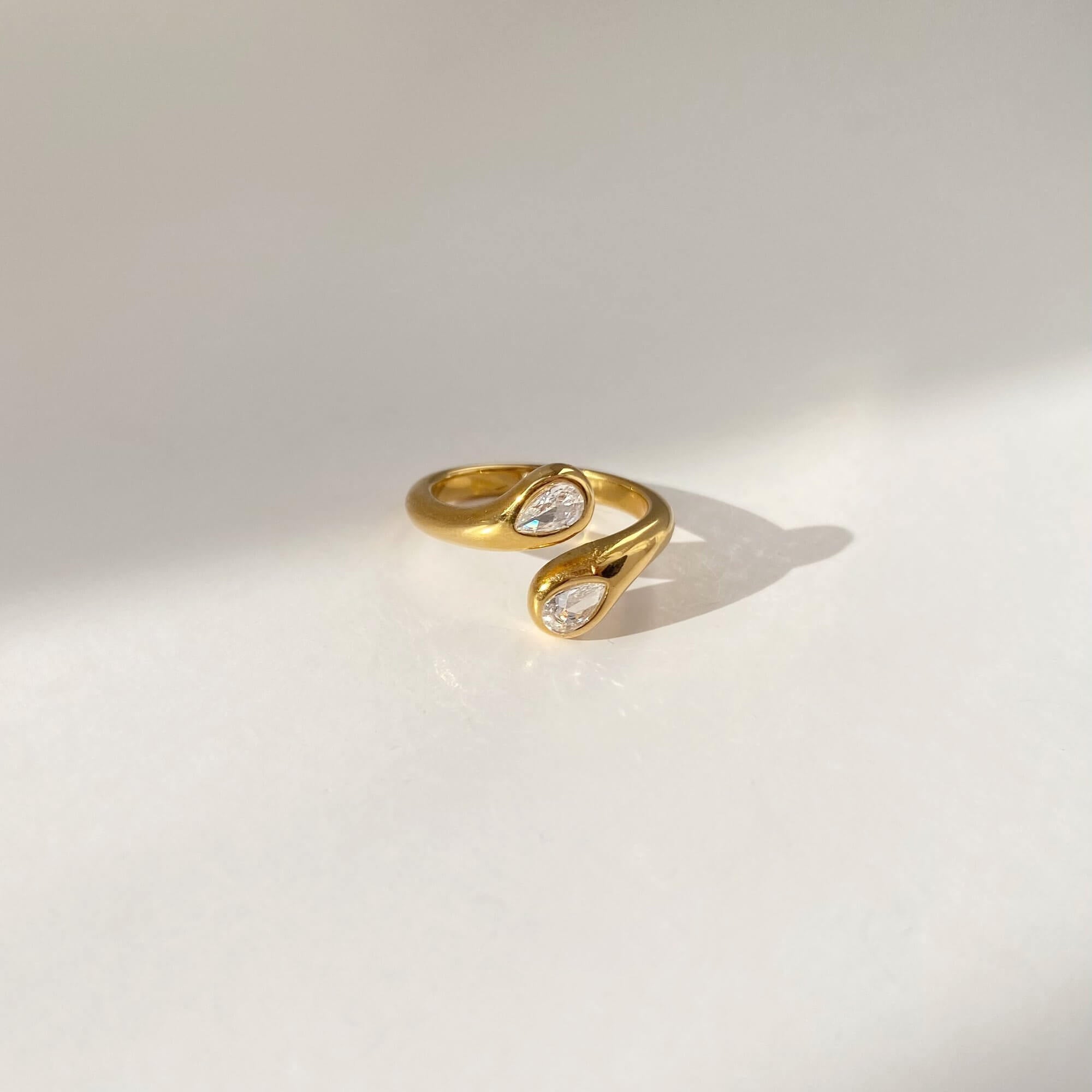 Close-up flat lay of the Kamilar pear wrap ring by Kampy Designs, showing the pear-shaped centerpiece and elegant band twist.