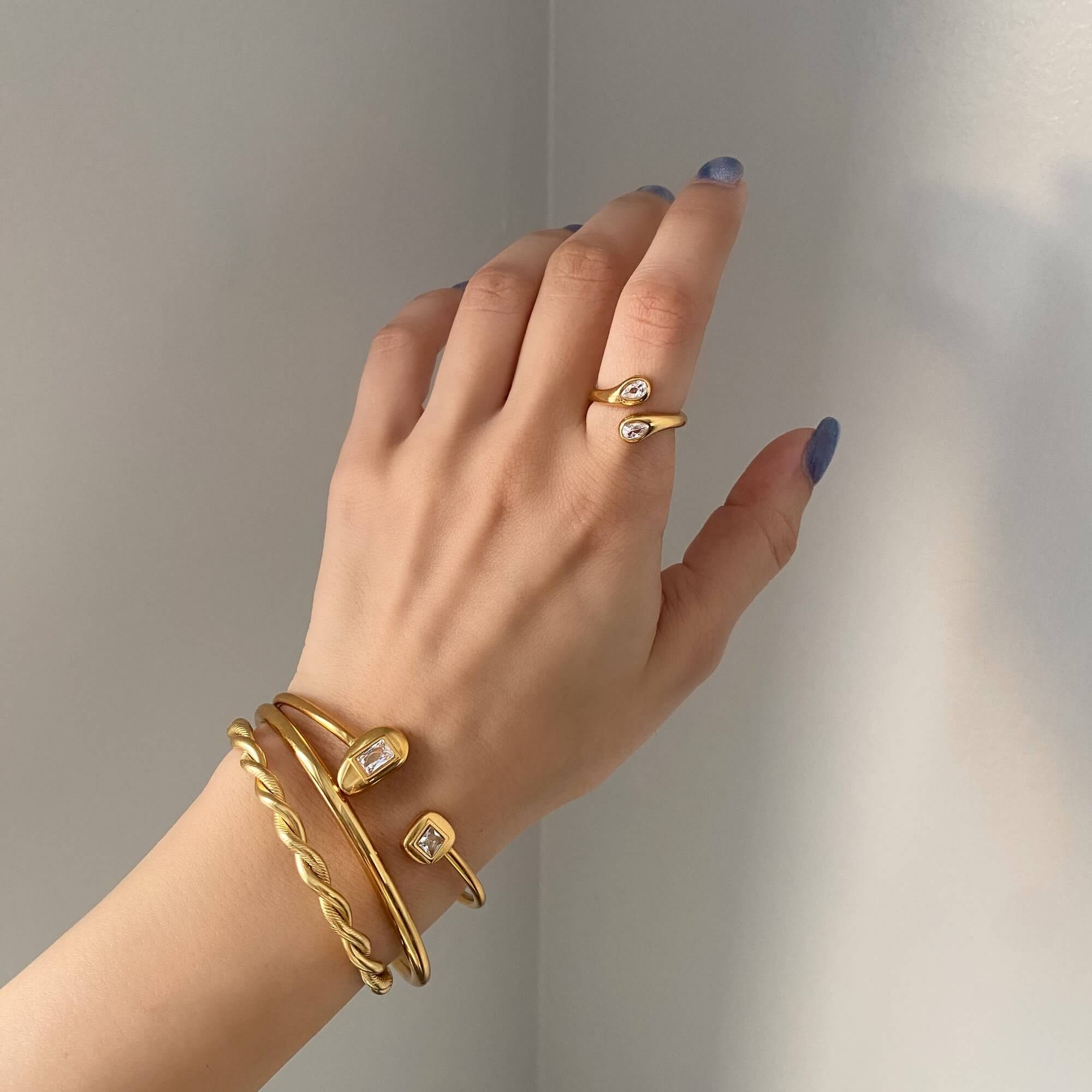 Close-up of the Kamilar pear wrap ring by Kampy Designs, worn on the model’s hand to highlight the pear-shaped gem and open ring design.