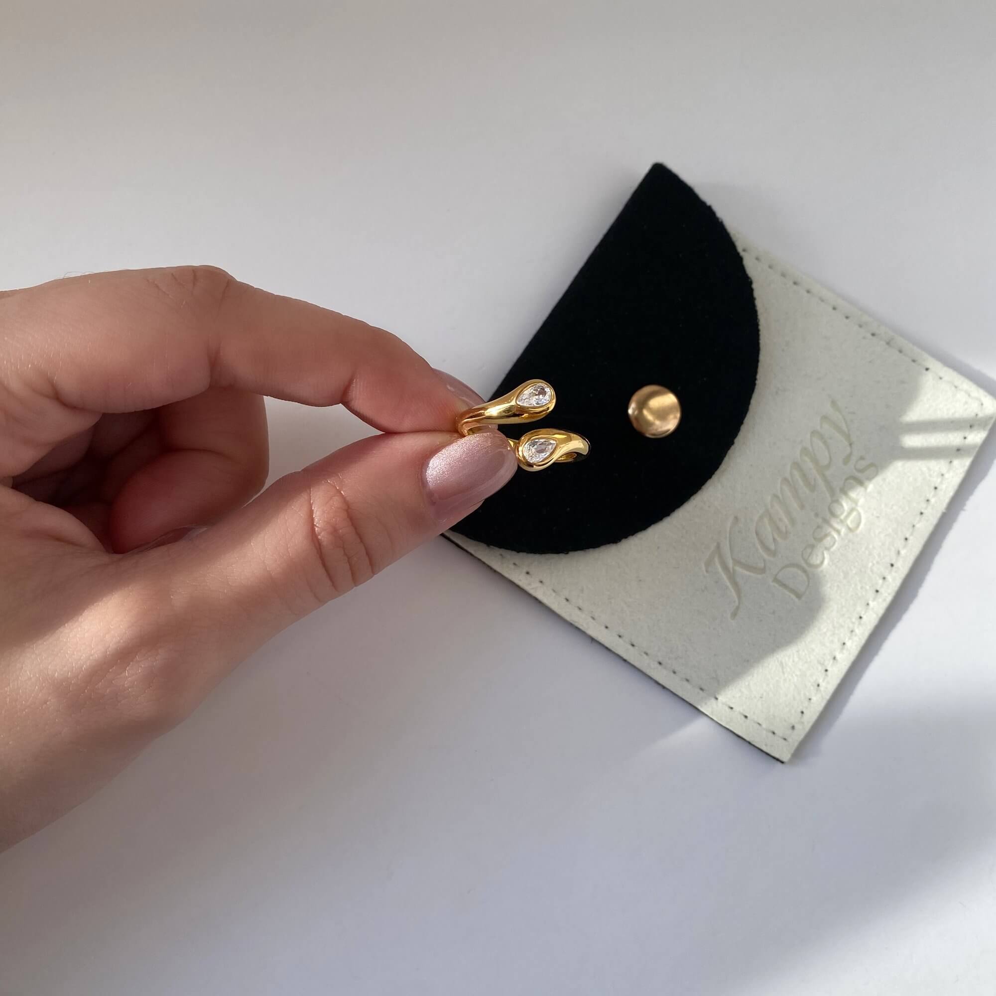 The Kamilar pear wrap ring by Kampy Designs, delicately held by model to emphasize the pear stone and gold-plated setting.