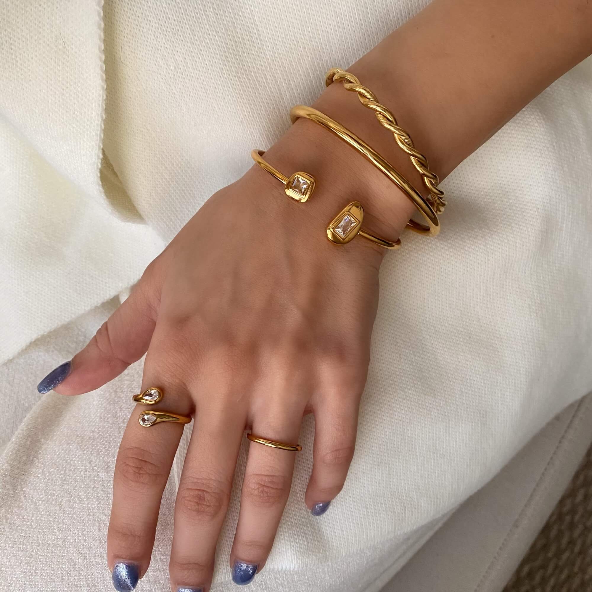 Stacked view of the Kamilar pear wrap ring by Kampy Designs, combined with other rings for a layered fashion statement.