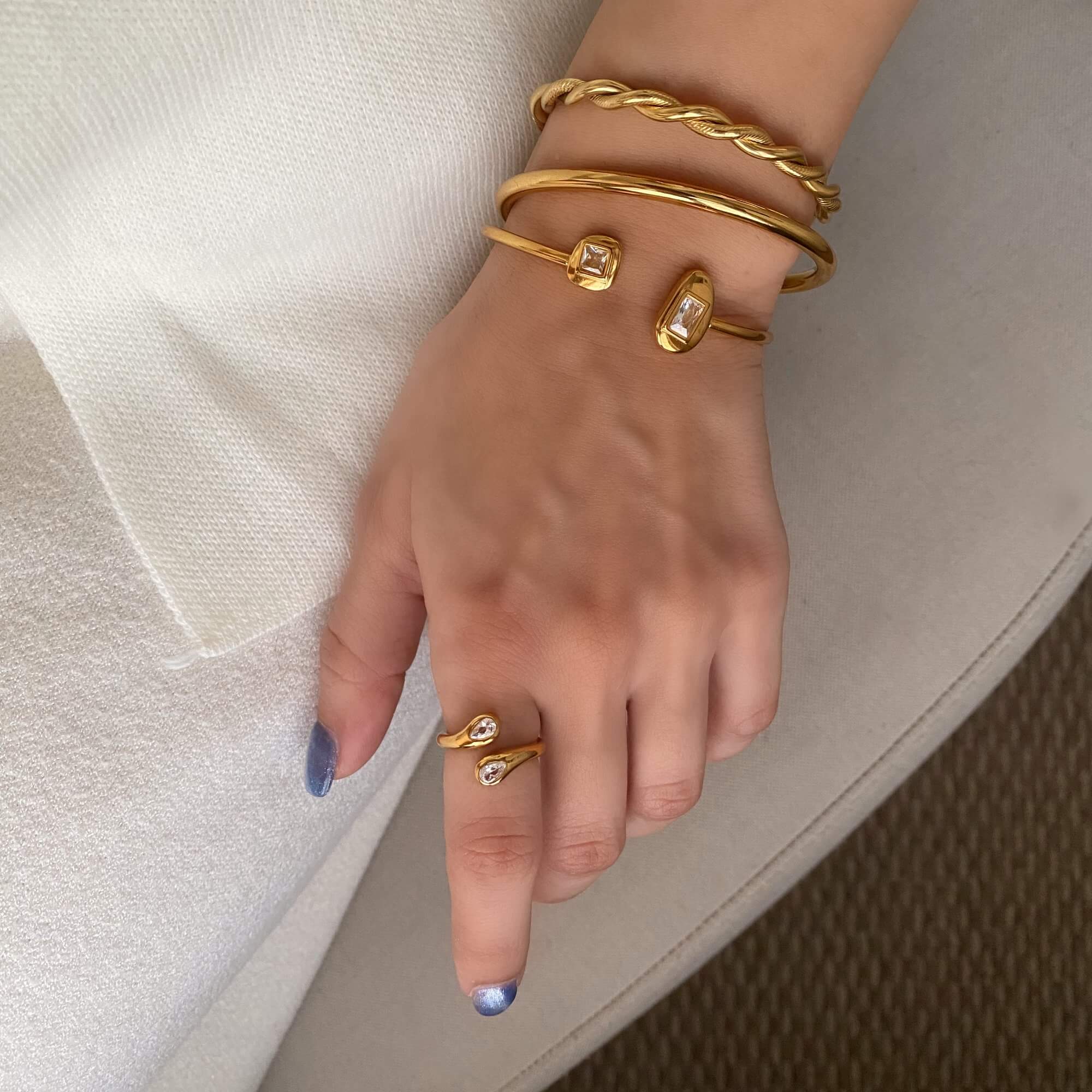 The Kamilar pear wrap ring by Kampy Designs, stacked on model with other pieces to showcase a trendy, stacked ring style.