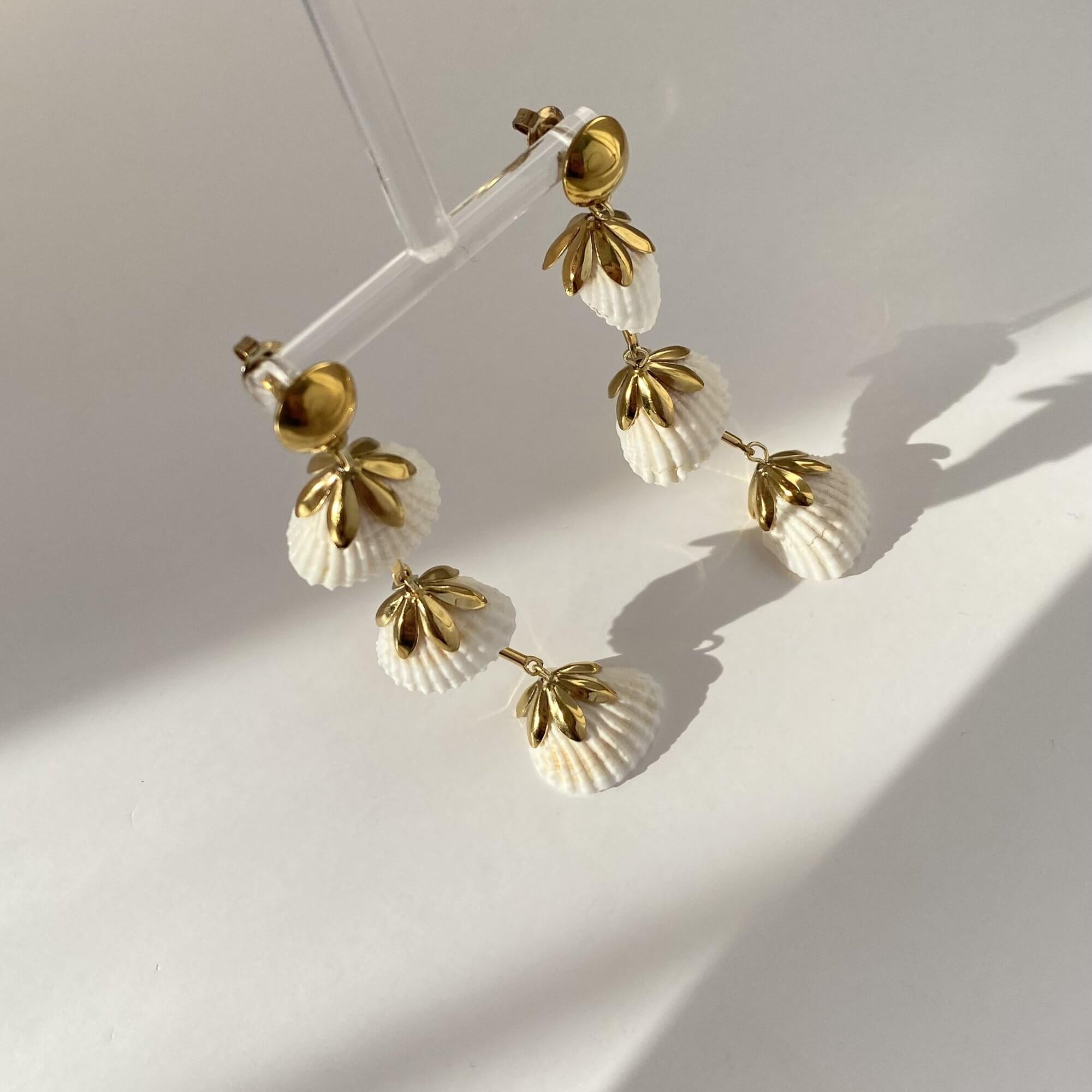 Flat lay of KlamidyaE real shell dangle earrings by Kampy Designs, featuring genuine shell drops with a golden finish.