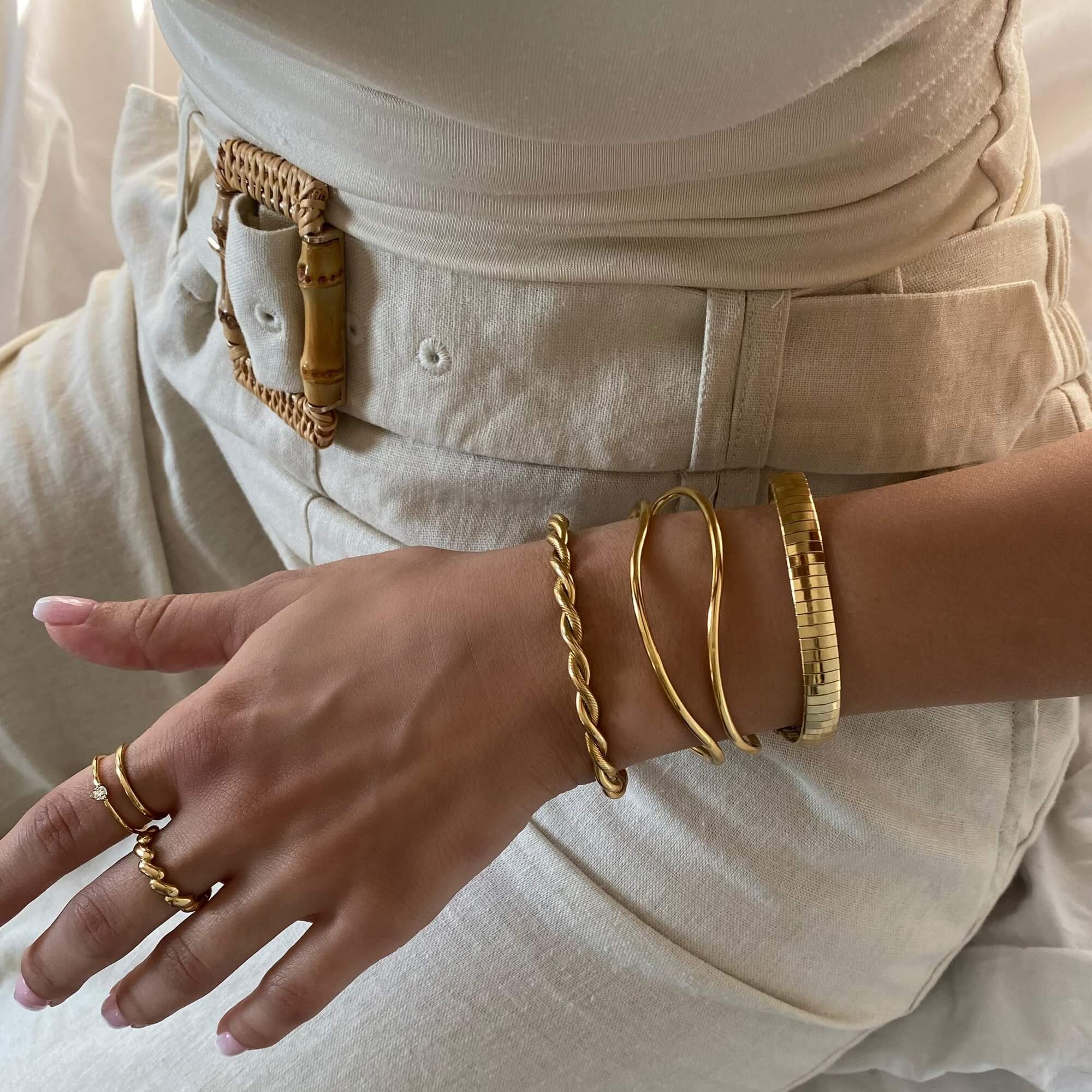Stacked view of the KyraB rope twist cuff bracelet in gold and two-toned by Kampy Designs, layered with other bracelets for a sophisticated look.