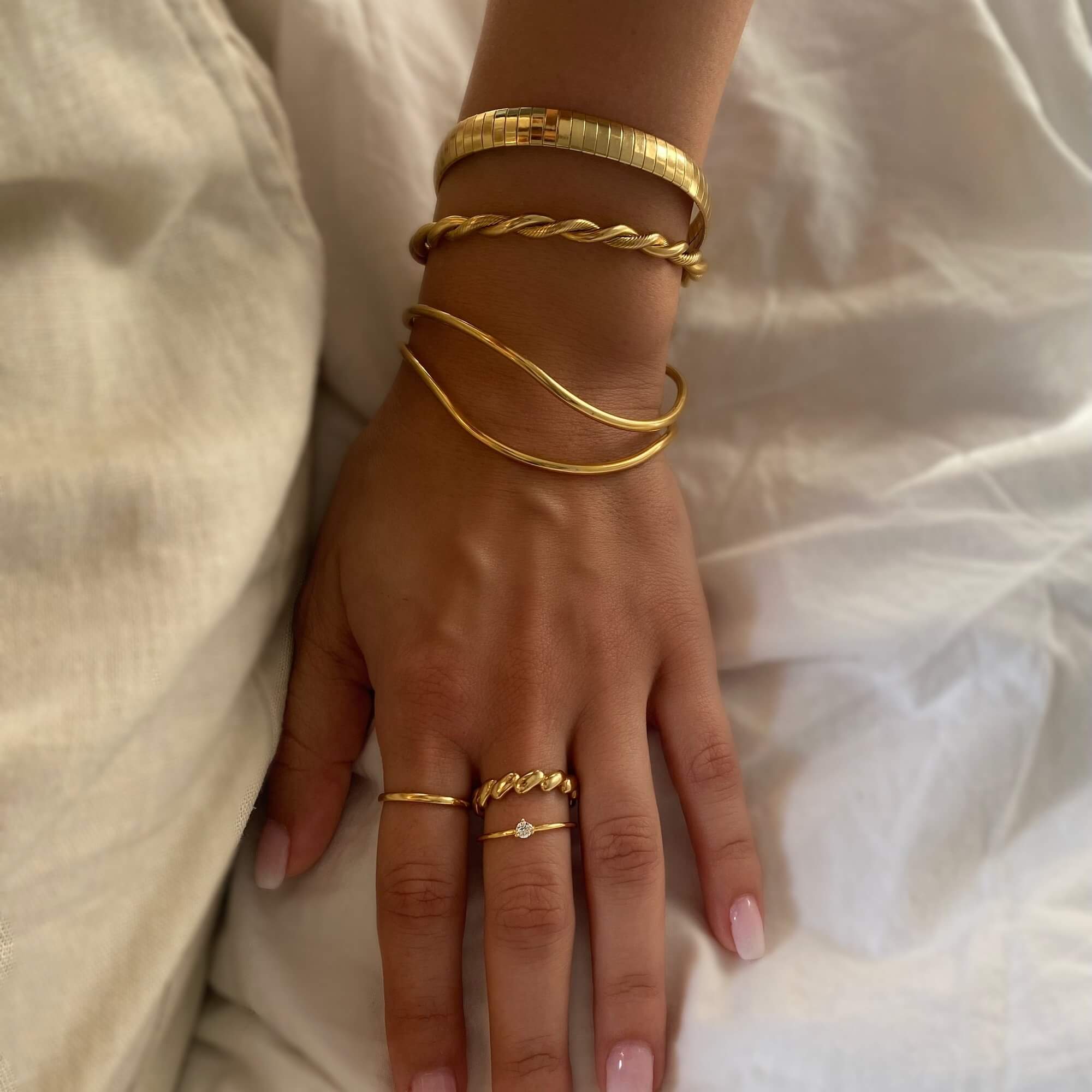 The KyraB rope twist cuff bracelet in gold and two-toned by Kampy Designs, elegantly worn to highlight its bold and luxurious appeal.