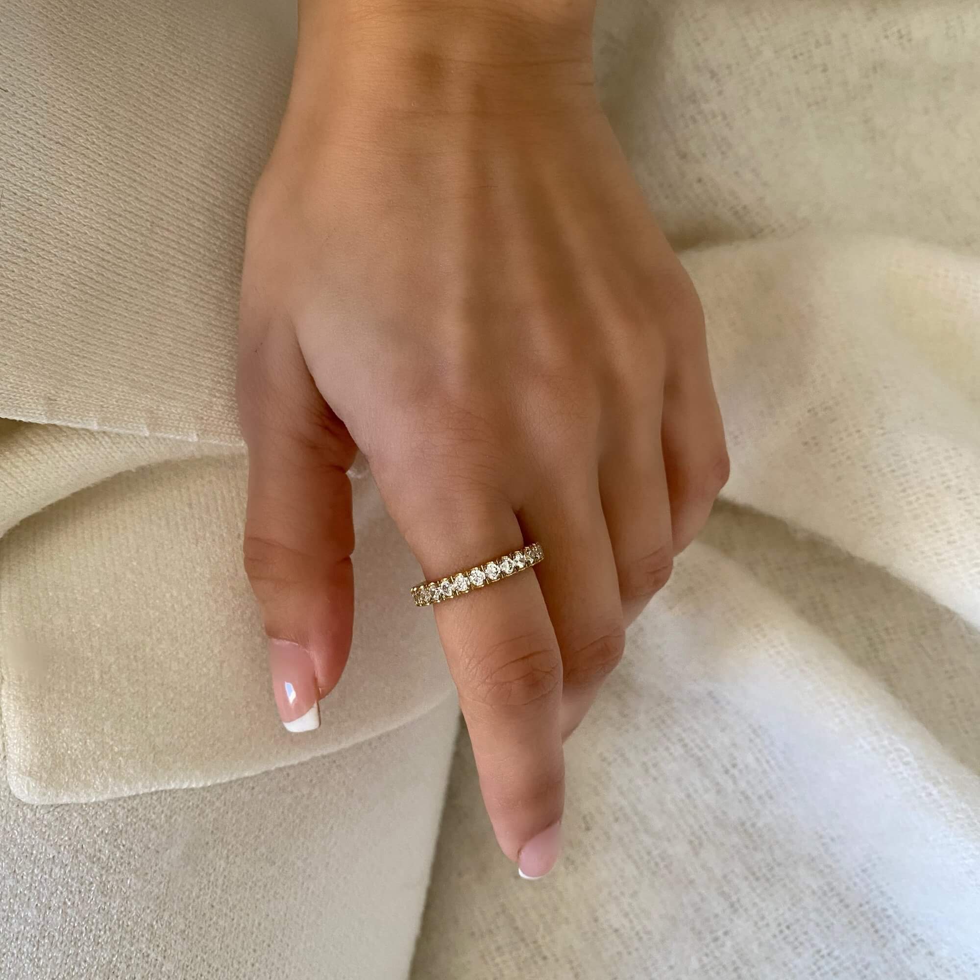 The KowR round diamond eternity band ring by Kampy Designs, worn on a model’s hand to showcase its sparkling diamonds and luxurious design.
