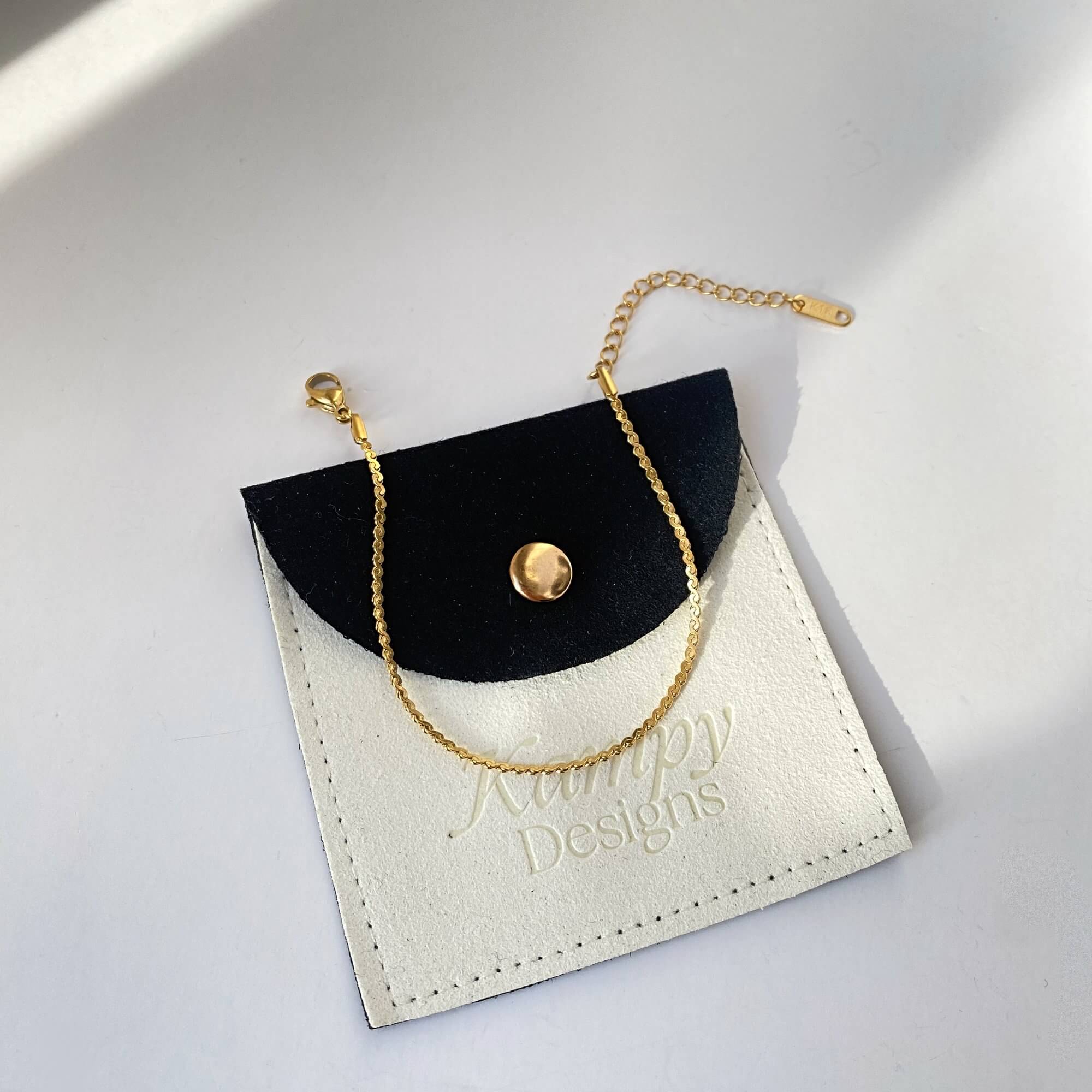 Flat lay of the KasaB S-link chain bracelet by Kampy Designs, showcasing its interlocking design and polished gold finish.