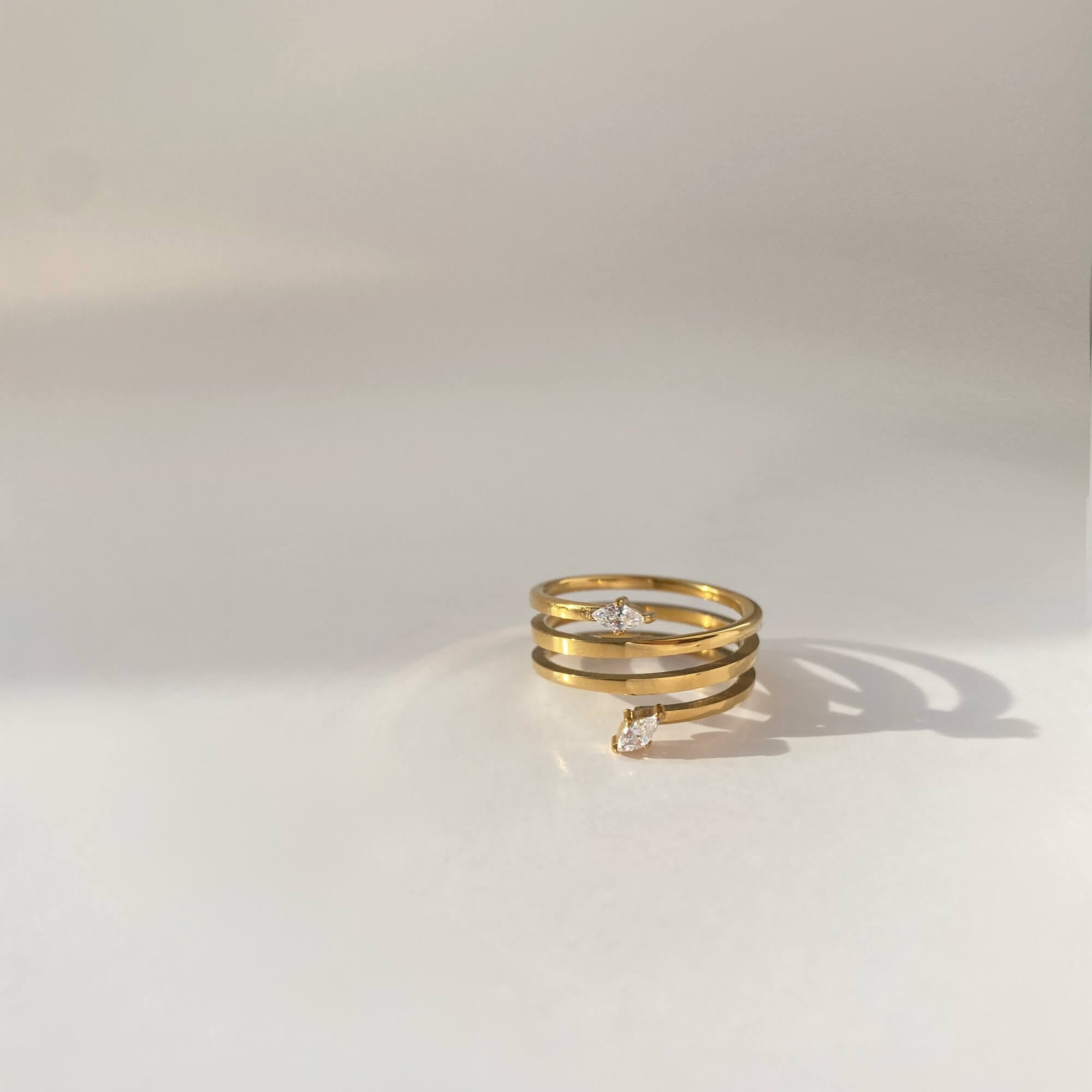 Flat lay of the Kinor serpentine wrap ring by Kampy Designs, revealing its coiled band and sleek polished finish.