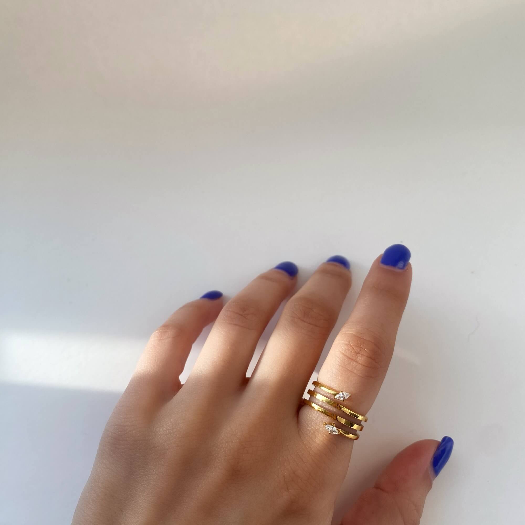 The Kinor serpentine wrap ring by Kampy Designs, worn on the model’s hand to display its unique winding band and luxurious texture.