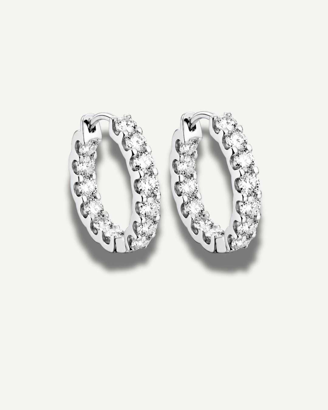 Silver moissanite huggie hoop earrings with round sparkling stones in a 20 mm hoop design by Kampy Designs.