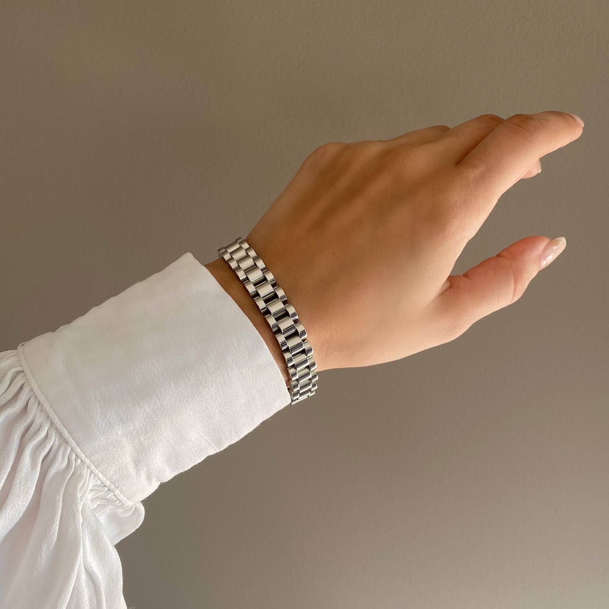 The KennedyB silver watch band bracelet by Kampy Designs, beautifully worn to showcase its sleek silver-tone band and sophisticated style.