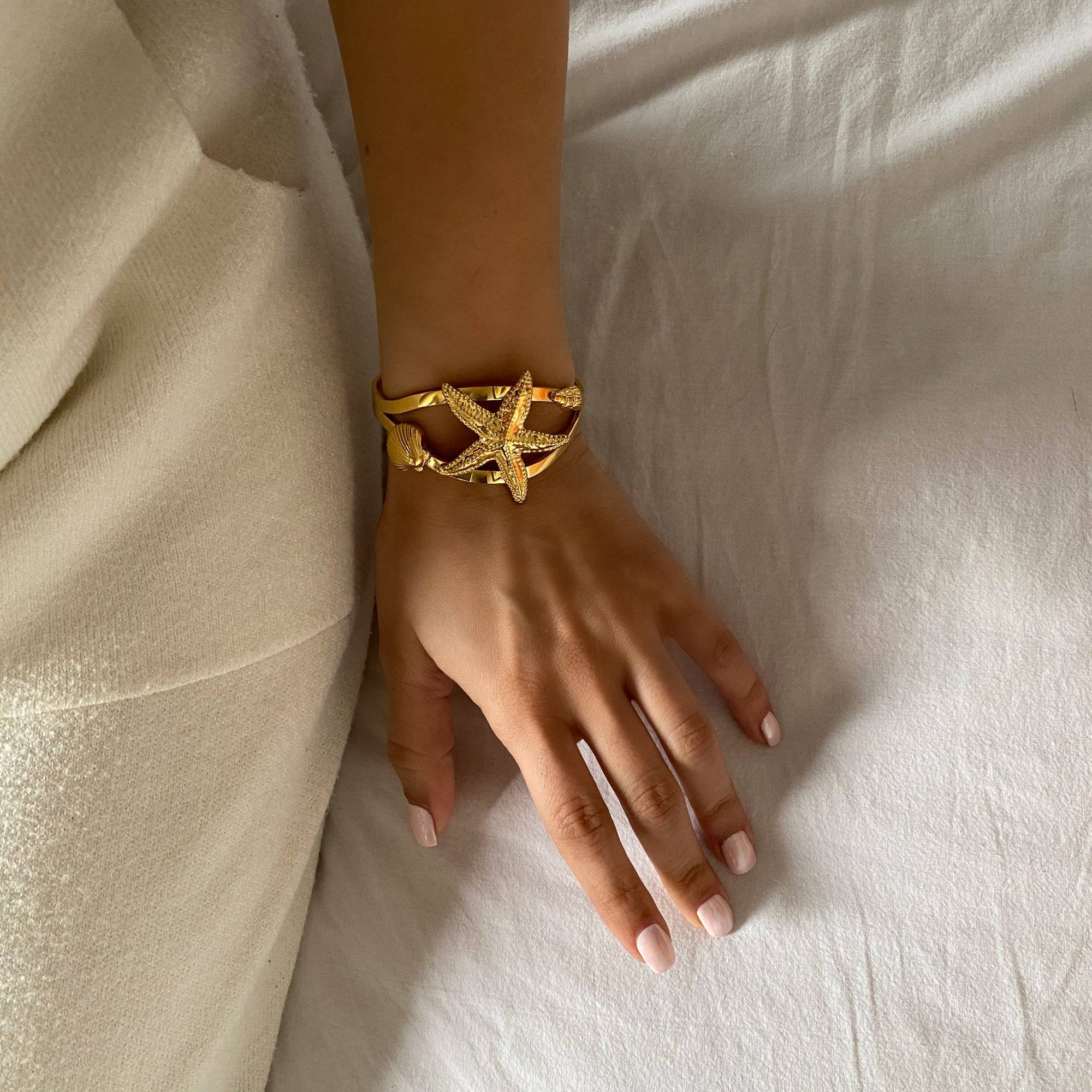 KoralB starfish cuff bracelet by Kampy Designs, shown at an angle on model’s wrist to highlight its ocean-inspired design and sculpted shape.