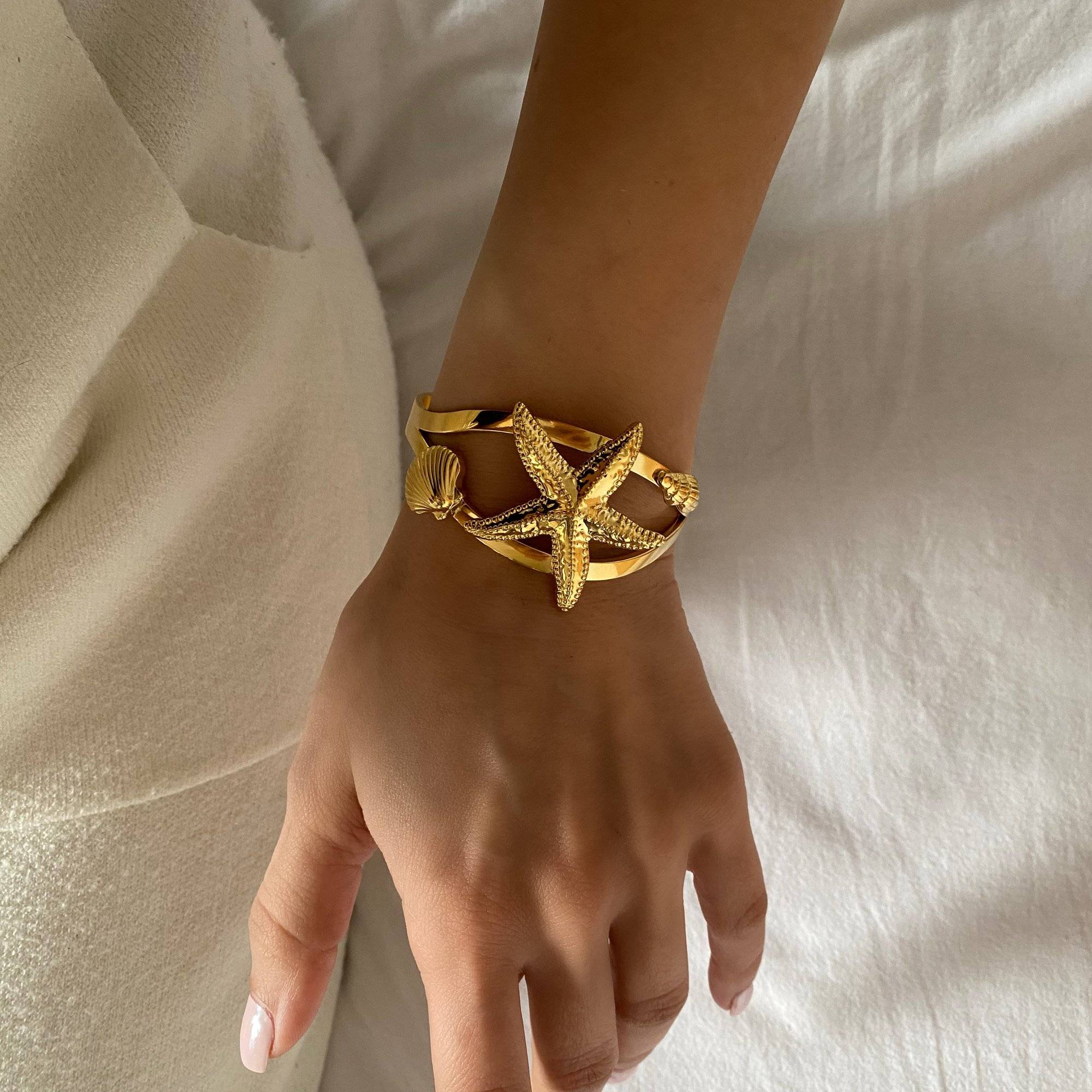 KoralB starfish cuff bracelet by Kampy Designs, captured in natural light on model's wrist to showcase its golden shine and textured finish.