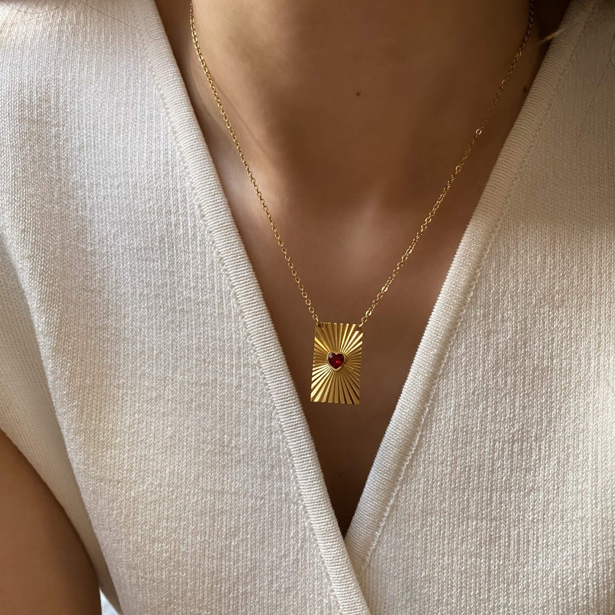 Angled view of the KearyN sunburst rectangle heart pendant necklace by Kampy Designs, showcasing its elegant engraved heart and radiant sunburst detailing.