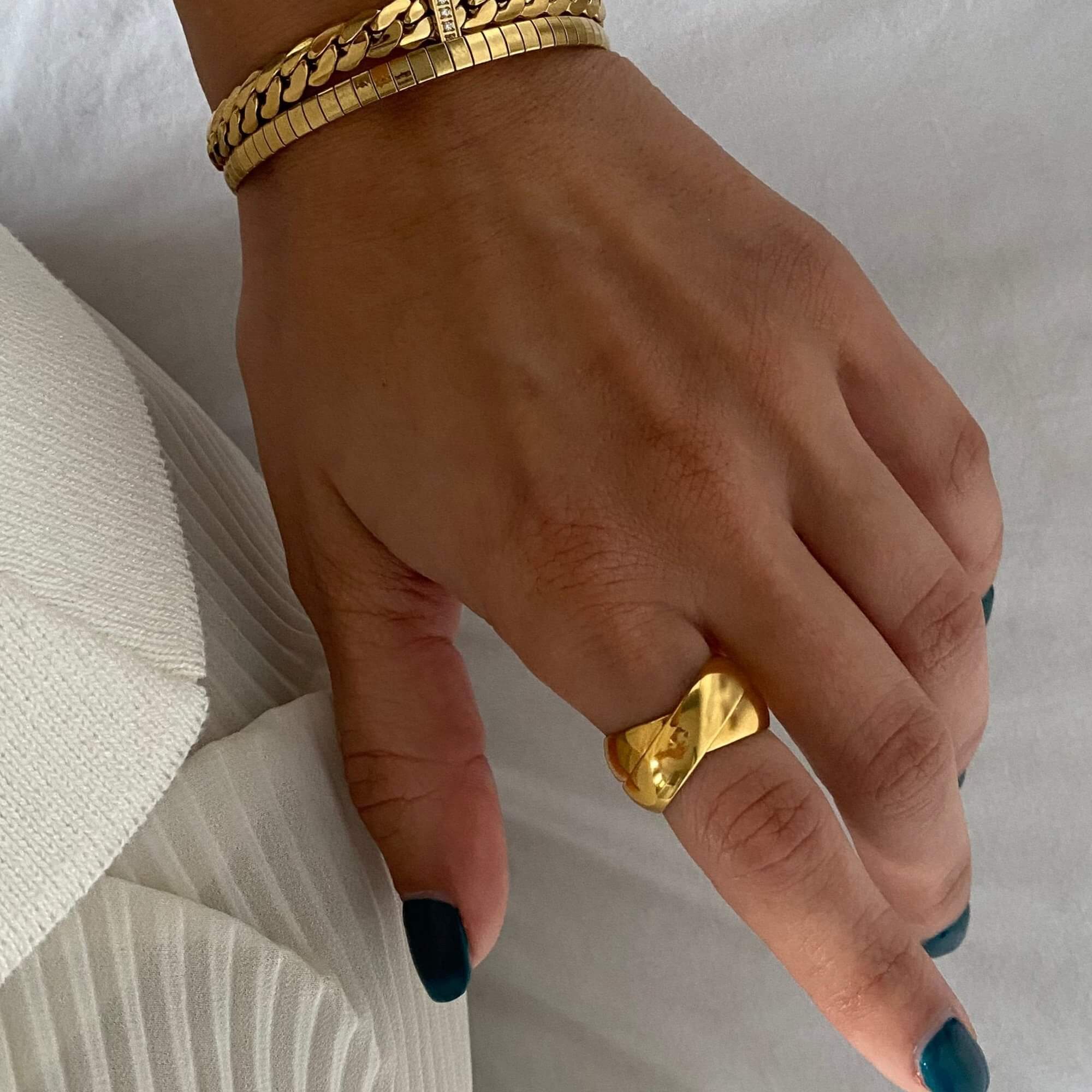 Angled view of the KatR thick interlocking ring by Kampy Designs, capturing its intricate overlapping loops and polished structure.