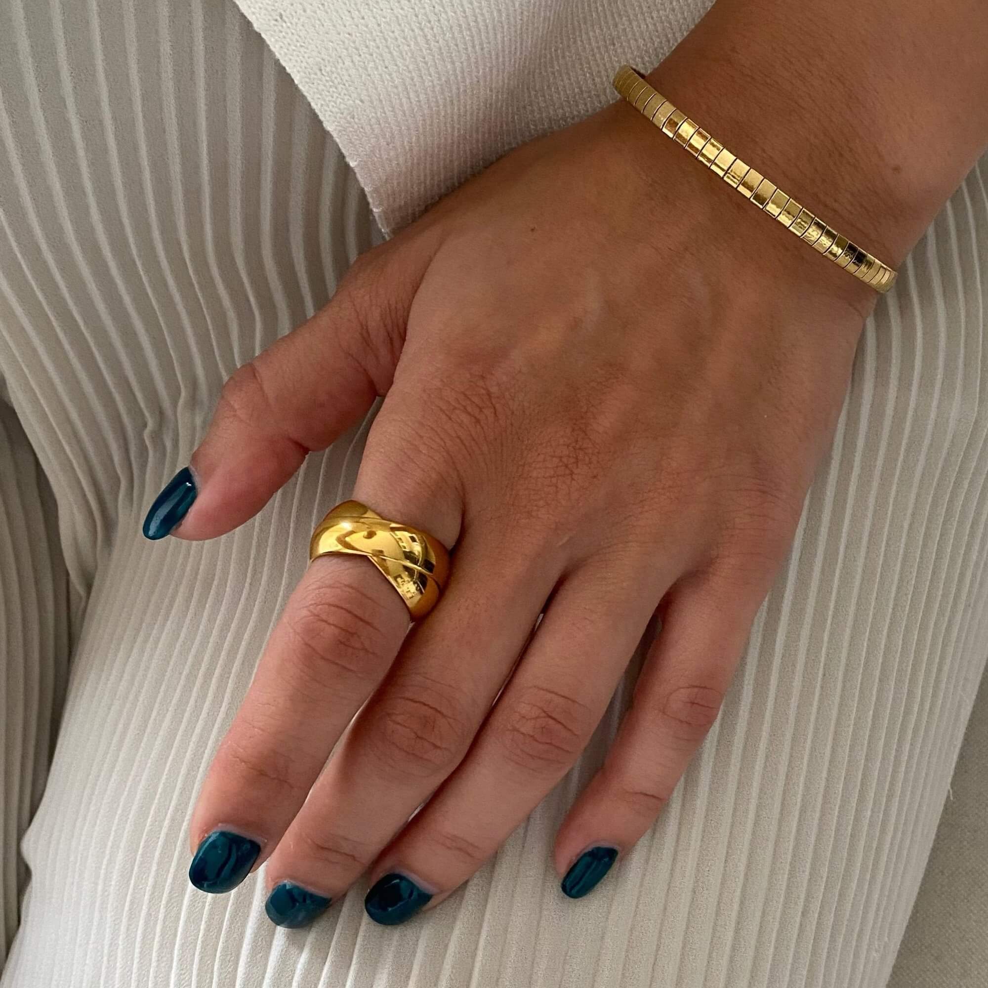 The KatR thick interlocking ring by Kampy Designs, elegantly worn to showcase its bold design and smooth gold finish.