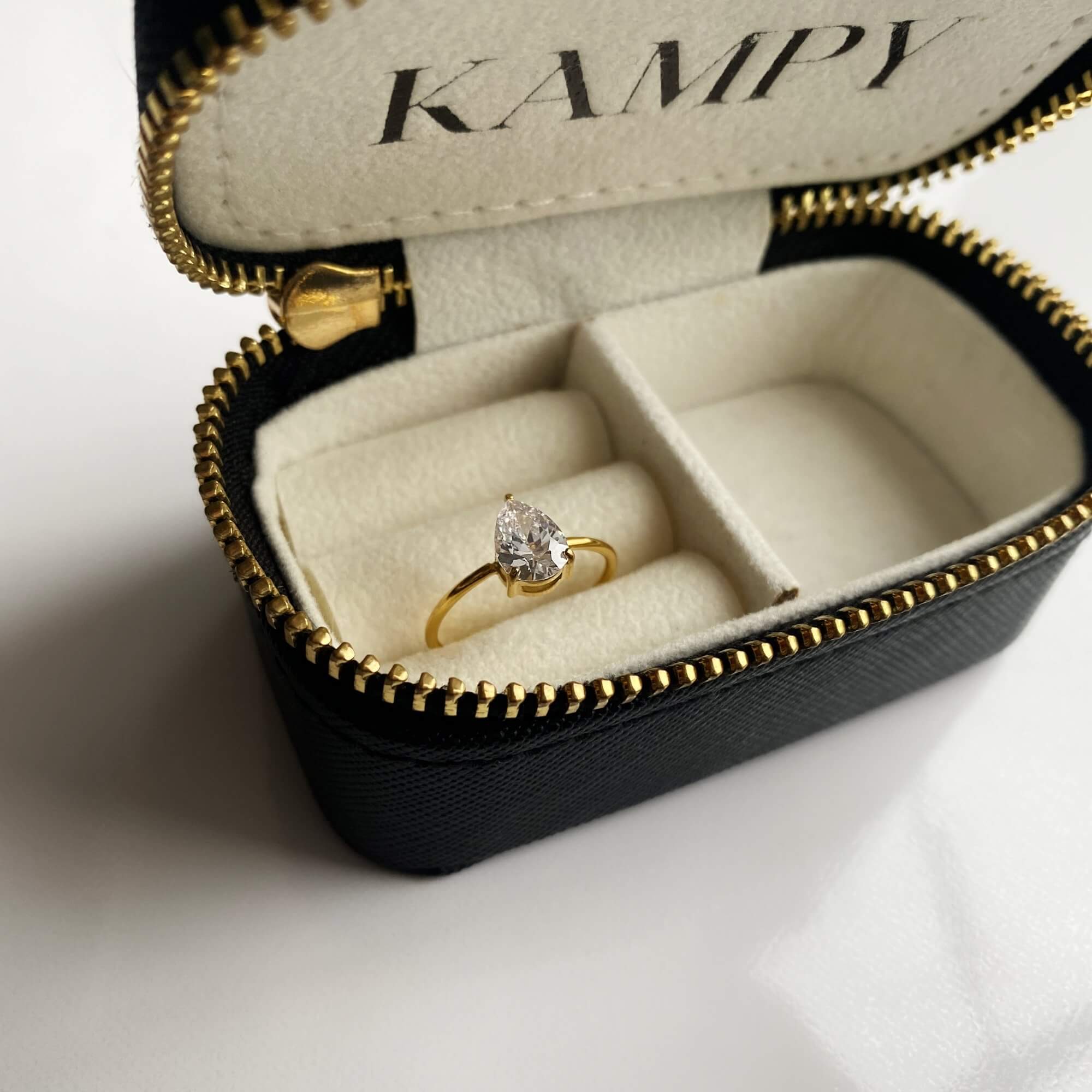 The KateR thin band pear-cut diamond ring by Kampy Designs, elegantly displayed on a jewelry stand to showcase its delicate and refined design.