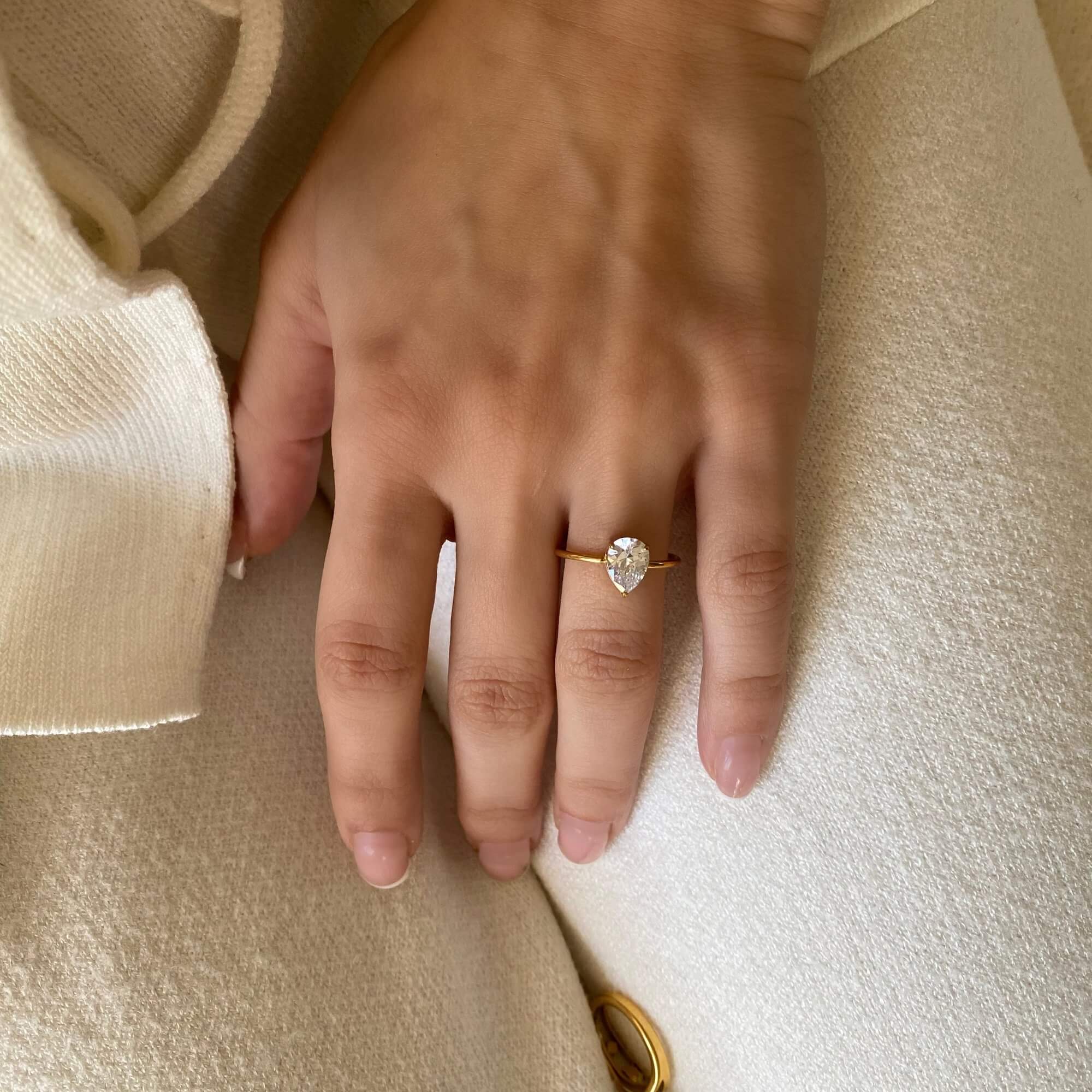 Top-down view of the KateR thin band pear-cut diamond ring by Kampy Designs, highlighting its sleek band and stunning pear-shaped diamond centerpiece.