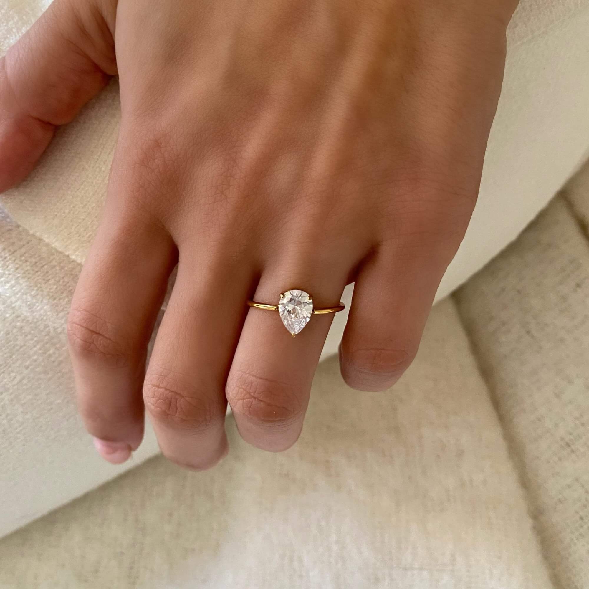 The KateR thin band pear-cut diamond ring by Kampy Designs, gracefully worn on a model’s hand to highlight its timeless elegance.