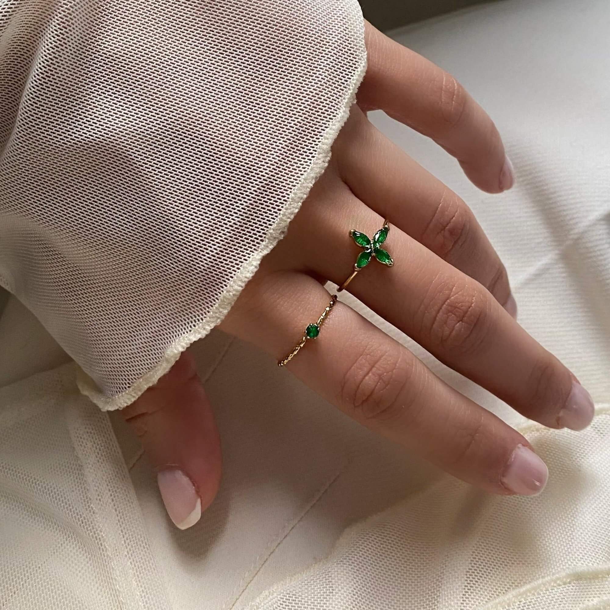The KikoR thin diamond stacker ring by Kampy Designs, styled elegantly with other rings to showcase its brilliant emerald gemstone and delicate diamond detailing.