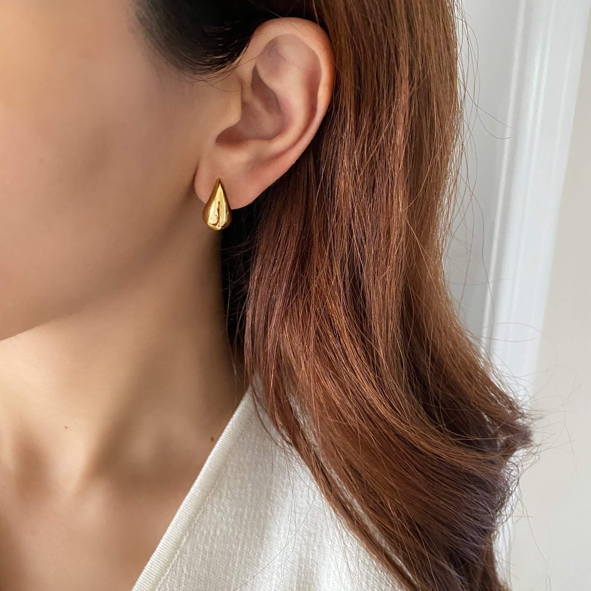 Alternative worn view of the KapreseE tiny gold tear drop earrings by Kampy Designs, showcasing their dainty and elegant teardrop shape.