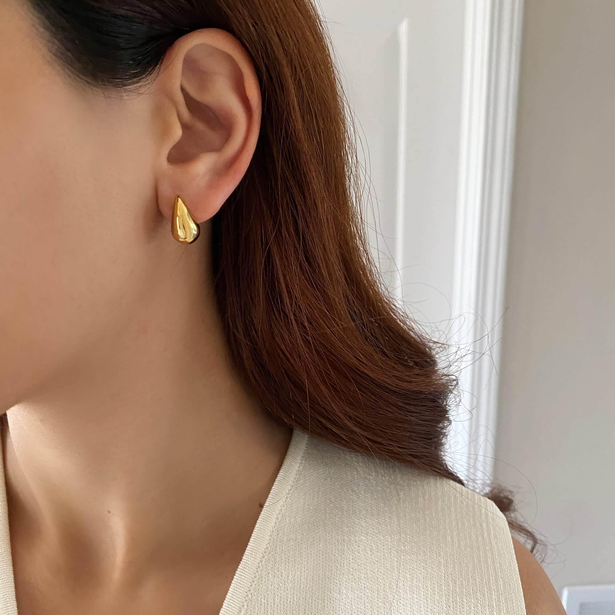The KapreseE tiny gold tear drop earrings by Kampy Designs, beautifully worn to highlight their delicate and sophisticated design.