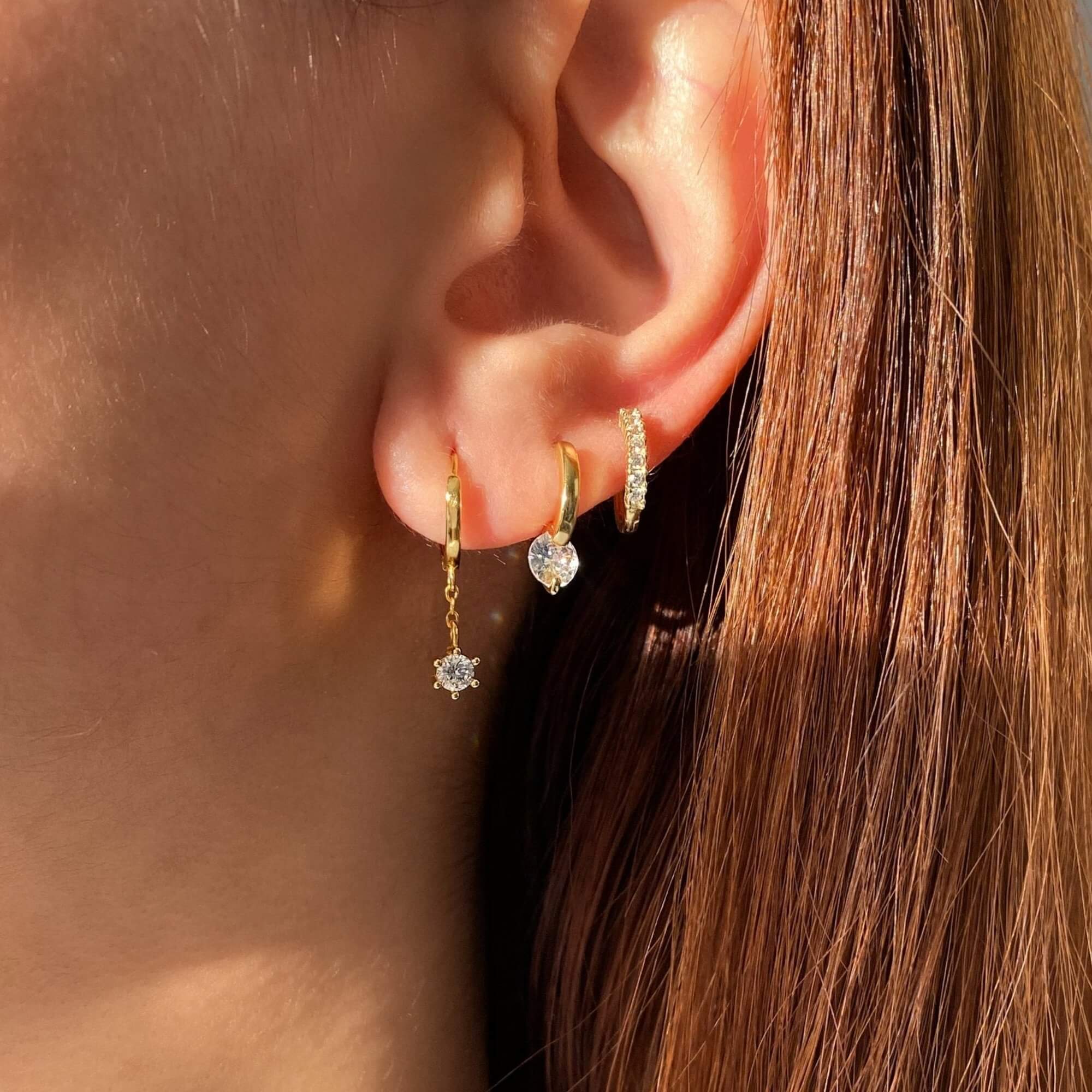 Side view of the KwalaE tiny hoop drop diamond earrings by Kampy Designs, showcasing their sleek gold hoop and brilliant diamond accents.