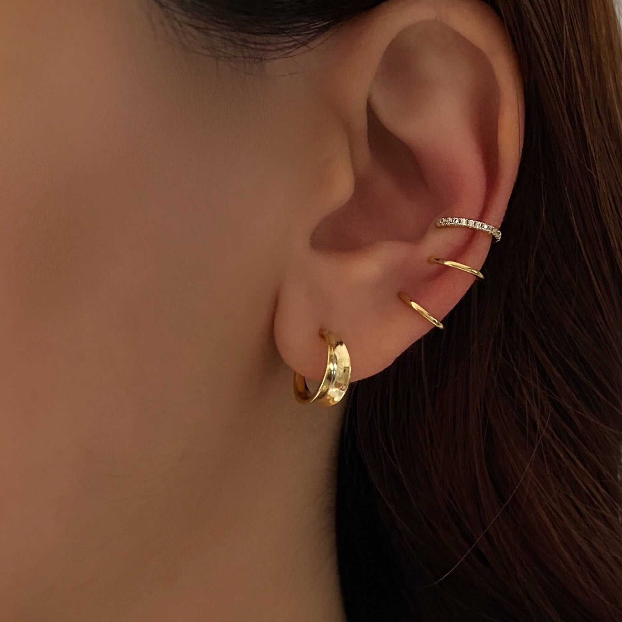 The KarlaE triple hoop CZ ear cuffs by Kampy Designs, stylishly worn to showcase their layered hoop design with sparkling cubic zirconia stones.