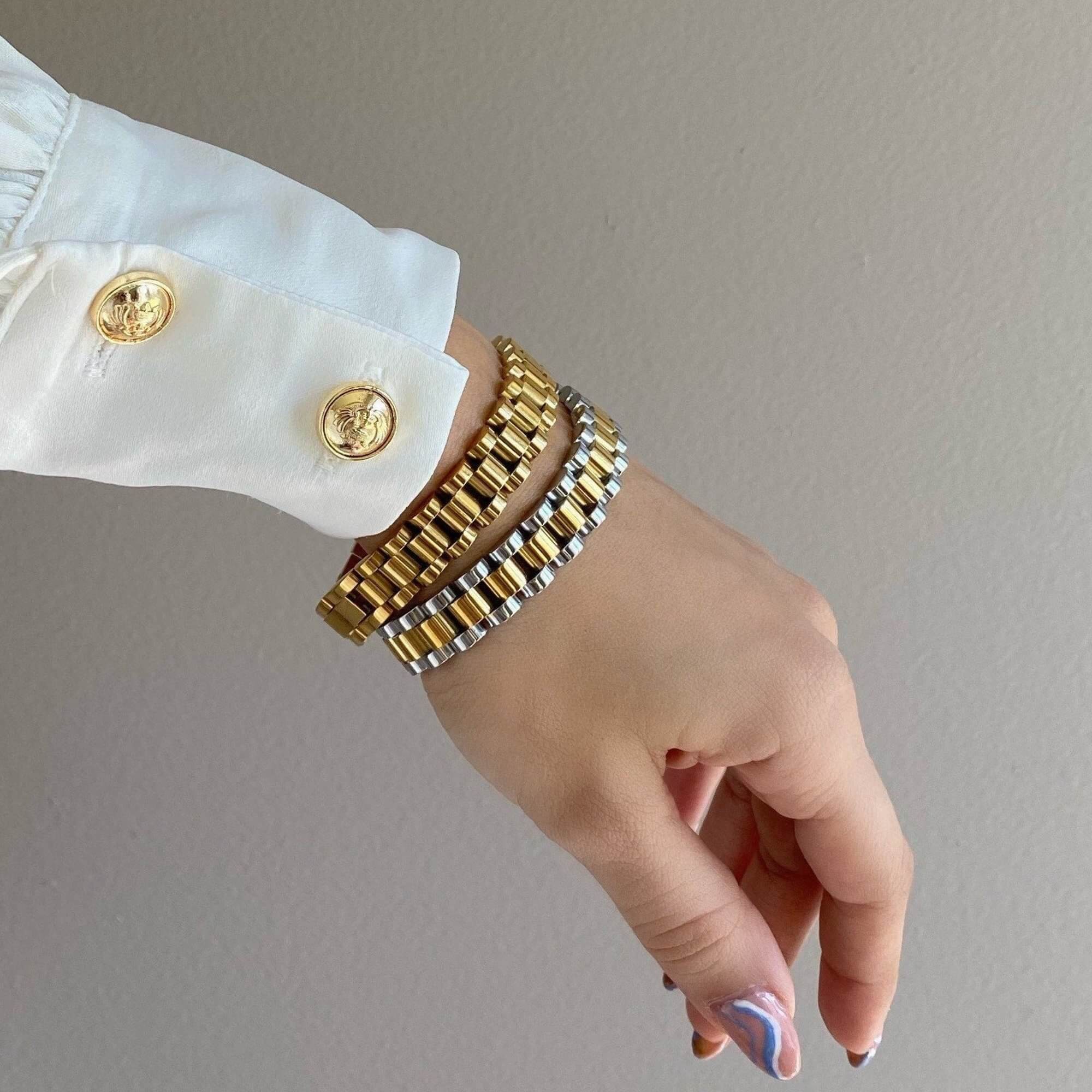 The KennedyB two-toned watch band bracelet by Kampy Designs, stacked with other bracelets for a layered, fashion-forward style.