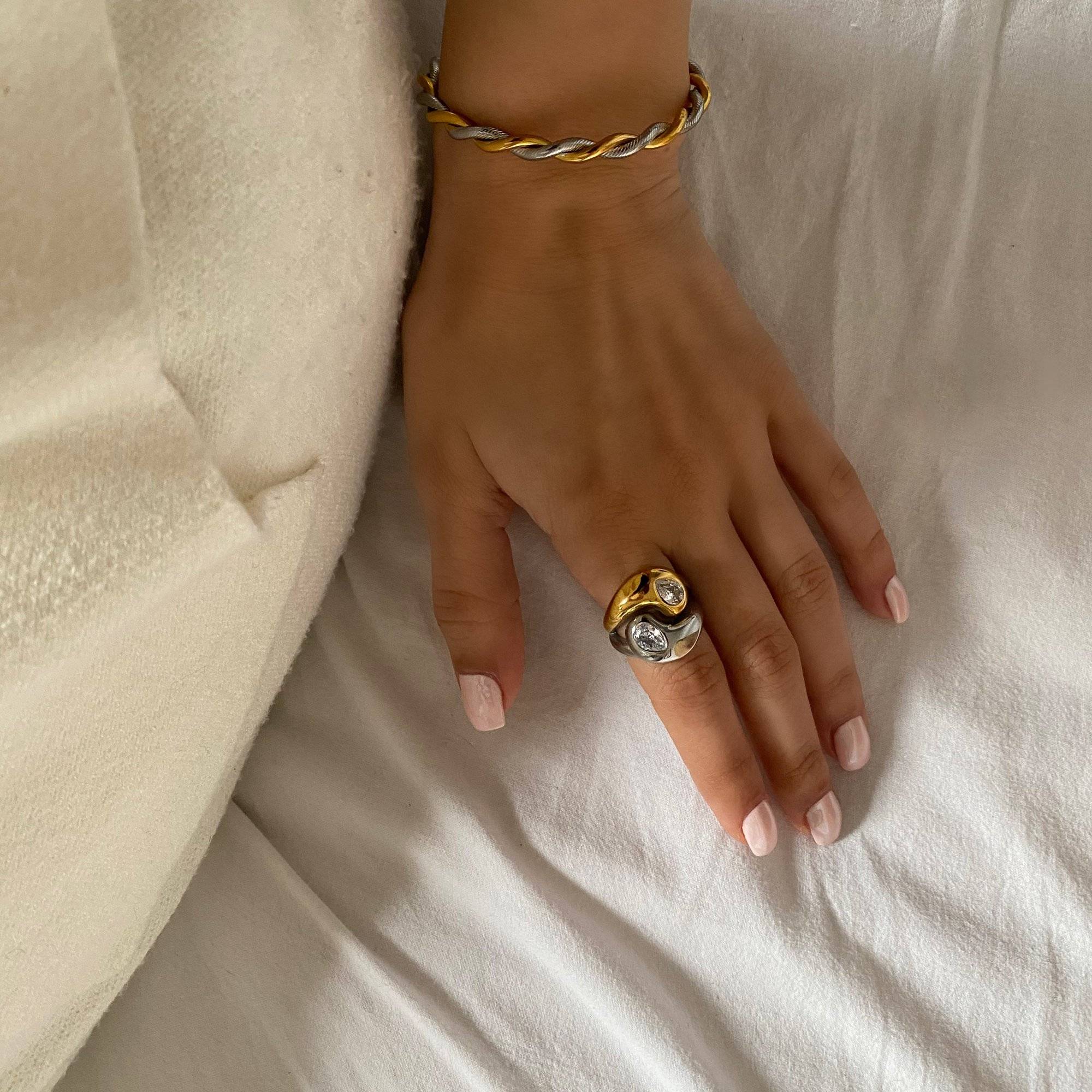 Angled styled view of the KangR yin yang ring by Kampy Designs, emphasizing the split-tone enamel face and elegant gold band.