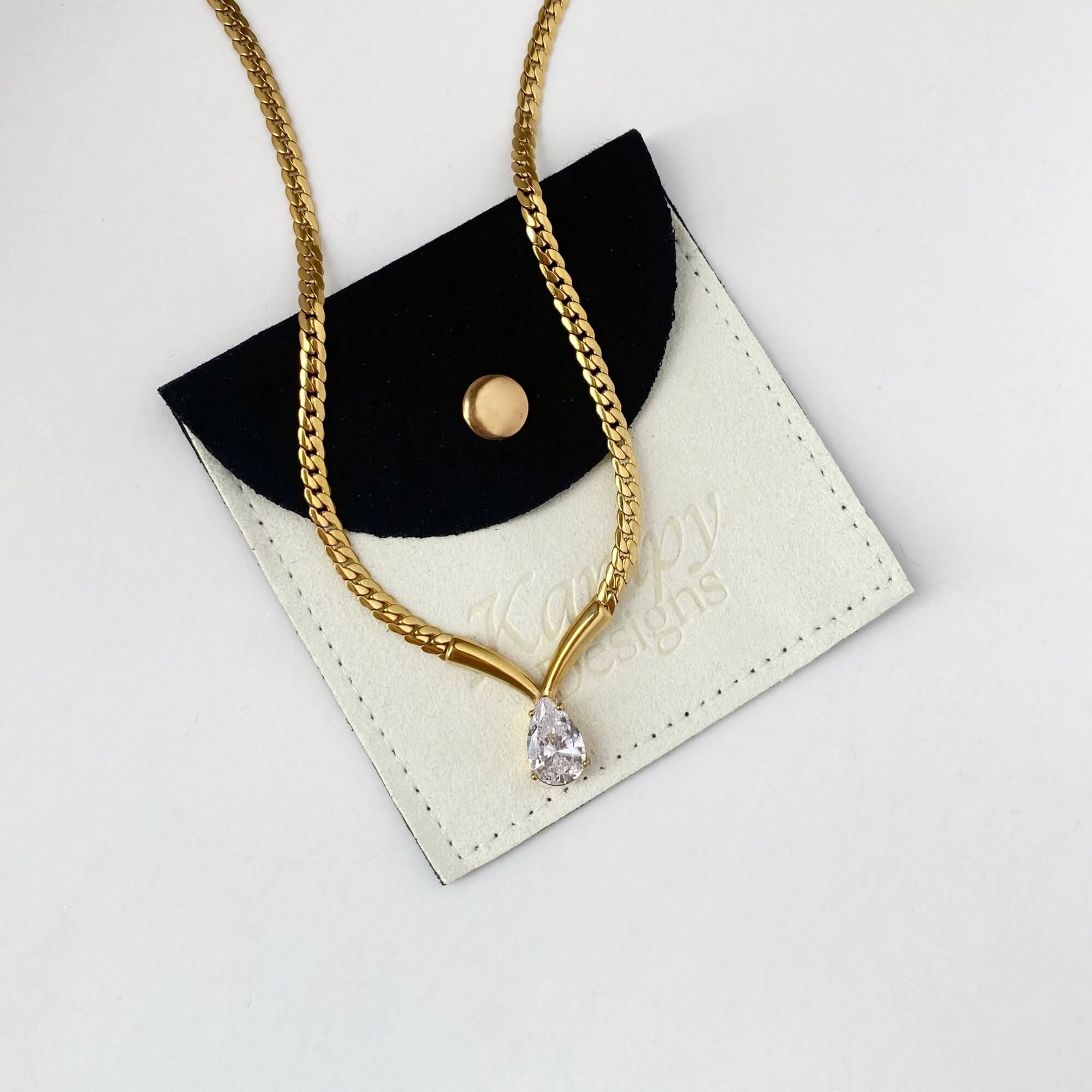 Branded flat lay of the Kaliyan V-chain necklace by Kampy Designs, presenting the necklace with elegant packaging and luxury branding.