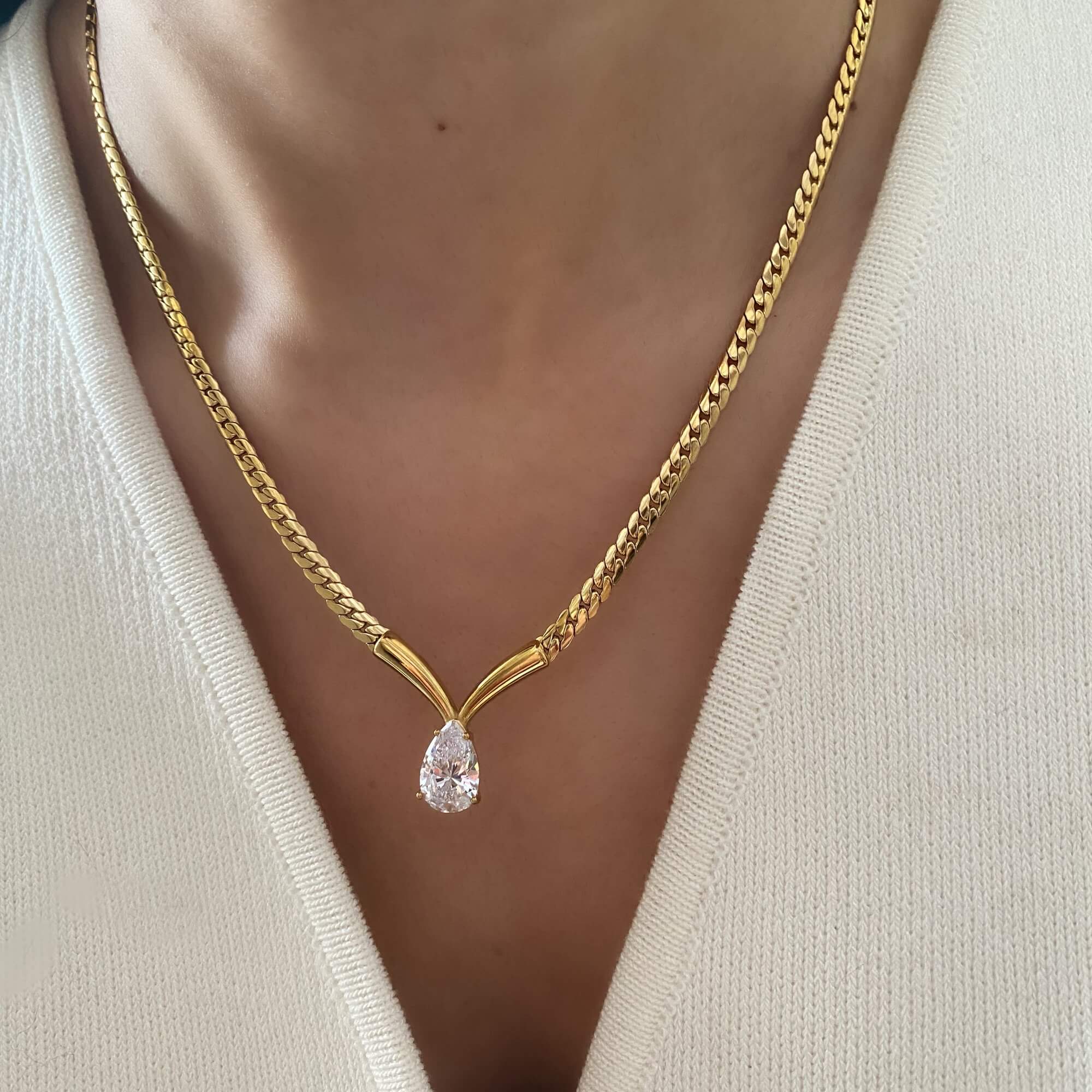 Close-up of the Kaliyan V-chain necklace with pear-shaped diamond by Kampy Designs, worn on model to display its radiant centerpiece.