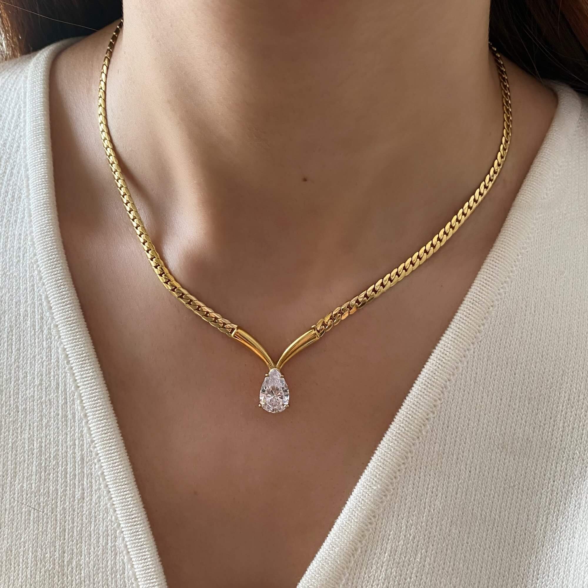 Worn around the neck, the Kaliyan V-chain necklace by Kampy Designs features a sparkling pear-shaped diamond and flattering V-shaped chain.