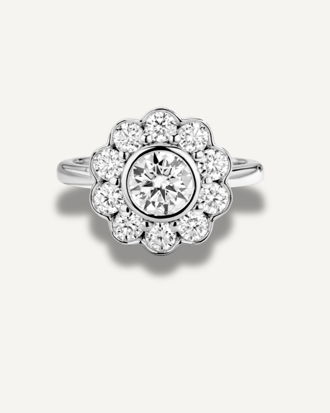 The Marigold Ring by Kampy Designs shown in silver, designed with a 1ct round moissanite center and ten 3mm moissanites forming a daisy-like floral halo bezel setting.