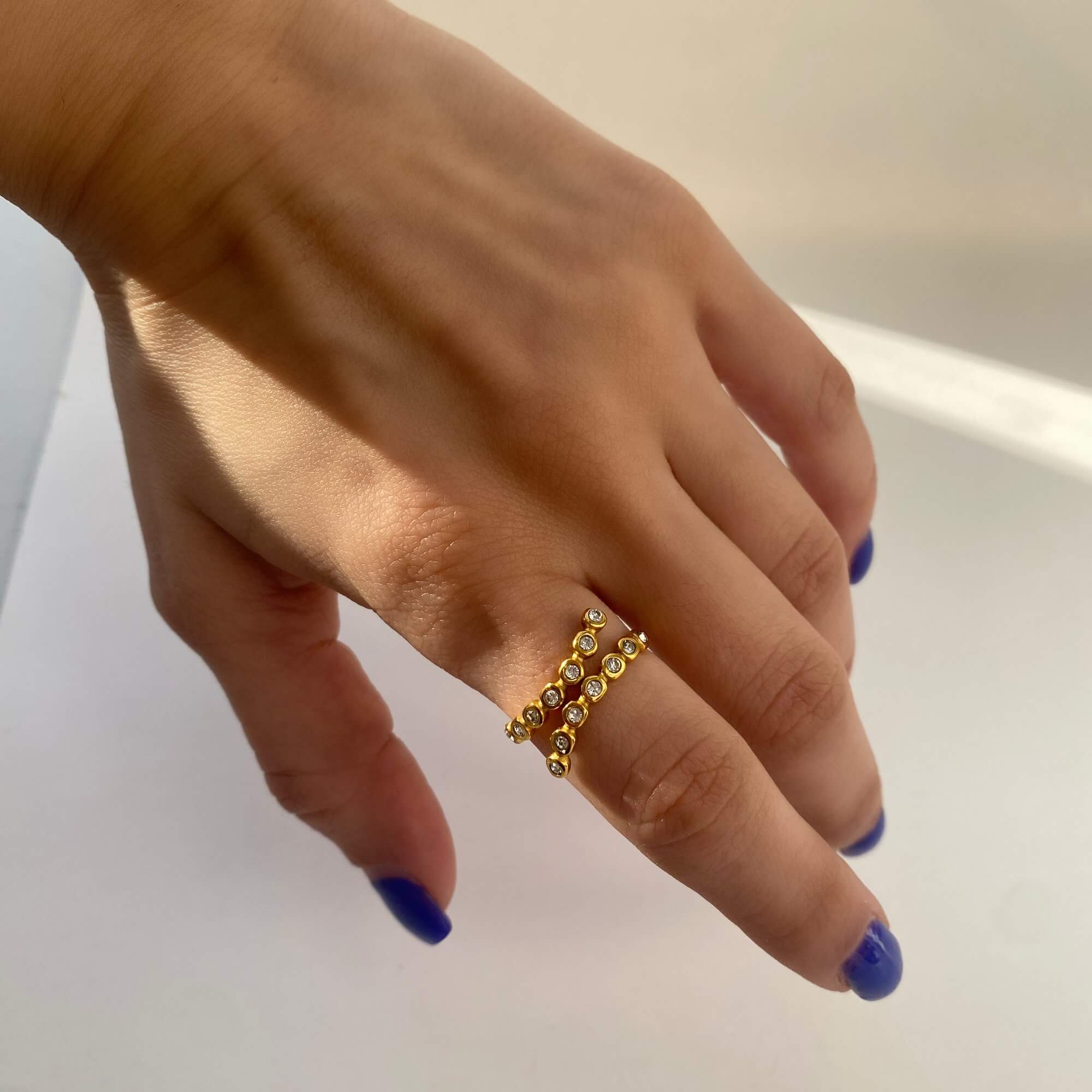 The KazzyR zircon bezel wrap ring by Kampy Designs, worn on the model’s hand to showcase its contemporary fit and radiant shimmer.