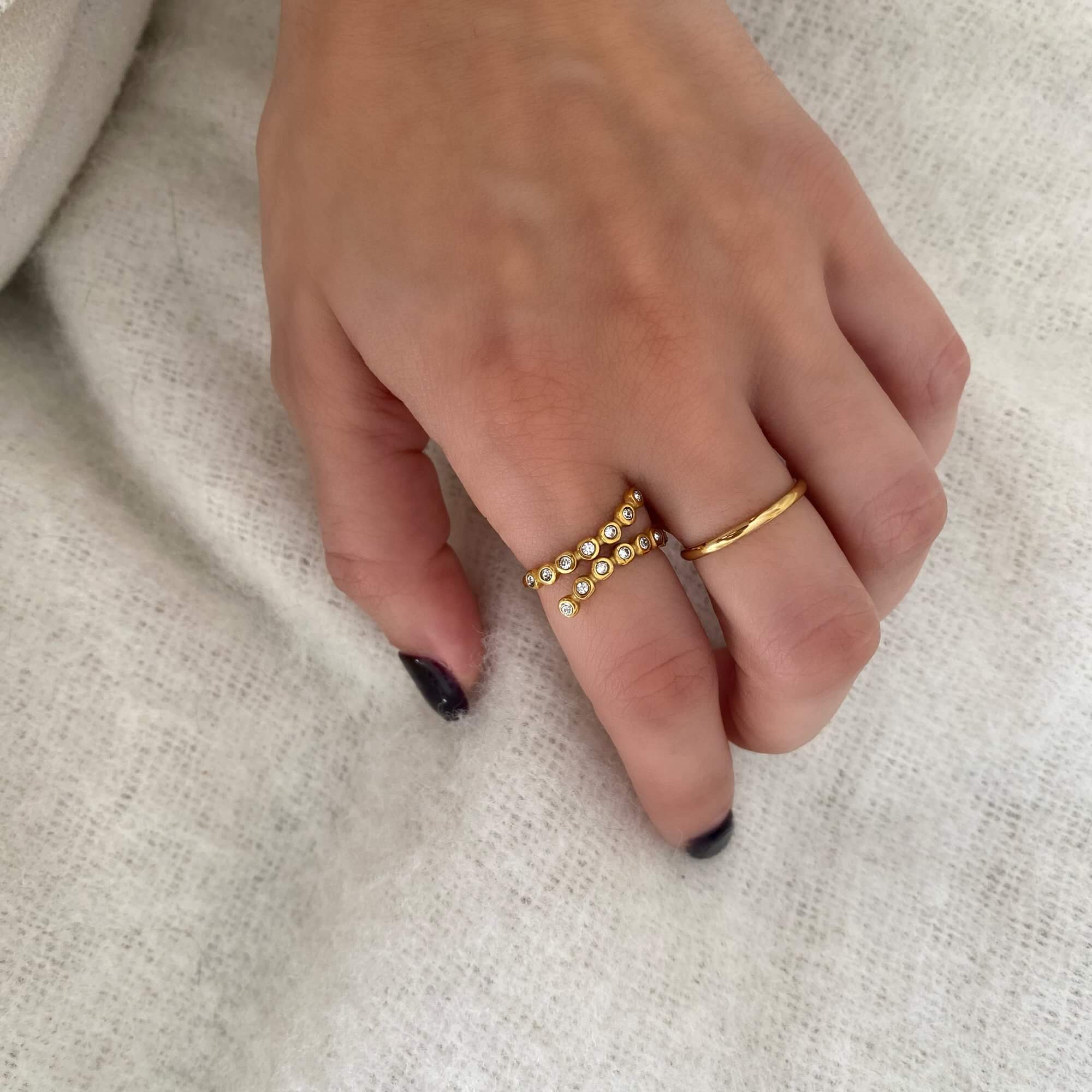 Top view of the KazzyR zircon bezel wrap ring by Kampy Designs, worn on the model’s hand to show its symmetry and minimalist appeal.