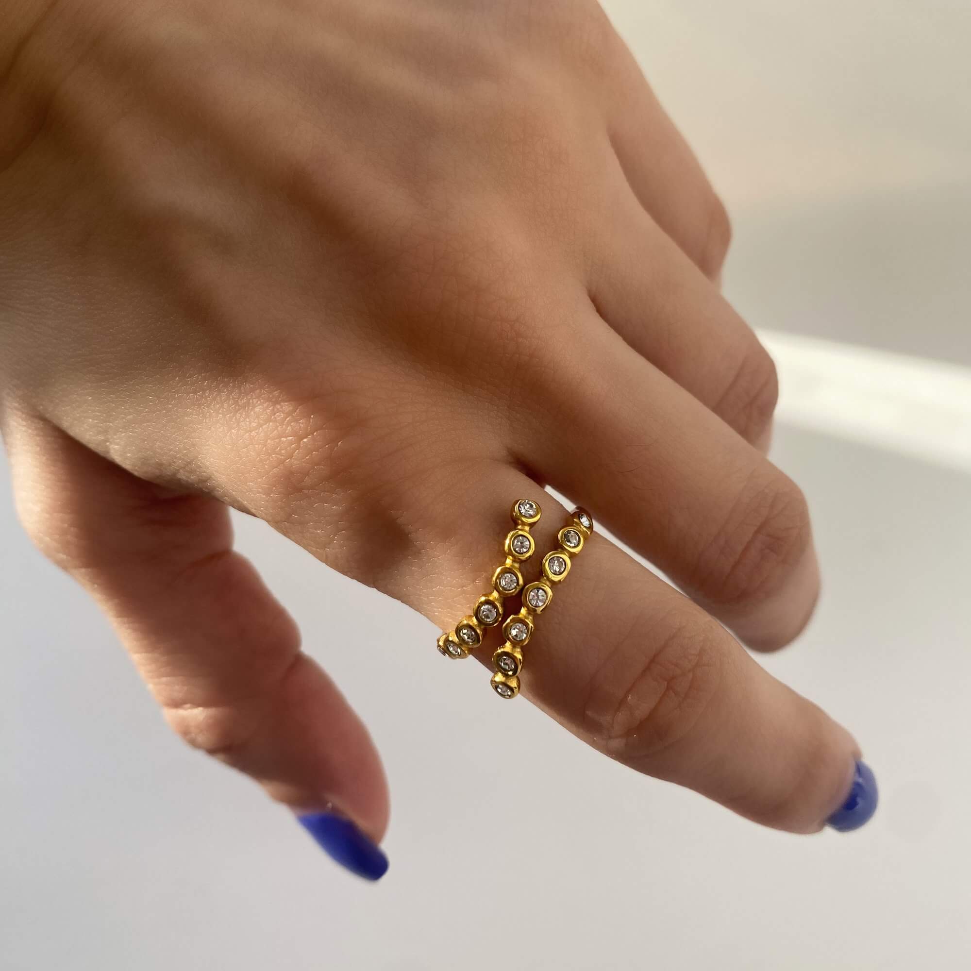 Close-up of the KazzyR zircon bezel wrap ring by Kampy Designs, highlighting its sparkling zircon center and elegant bezel setting.