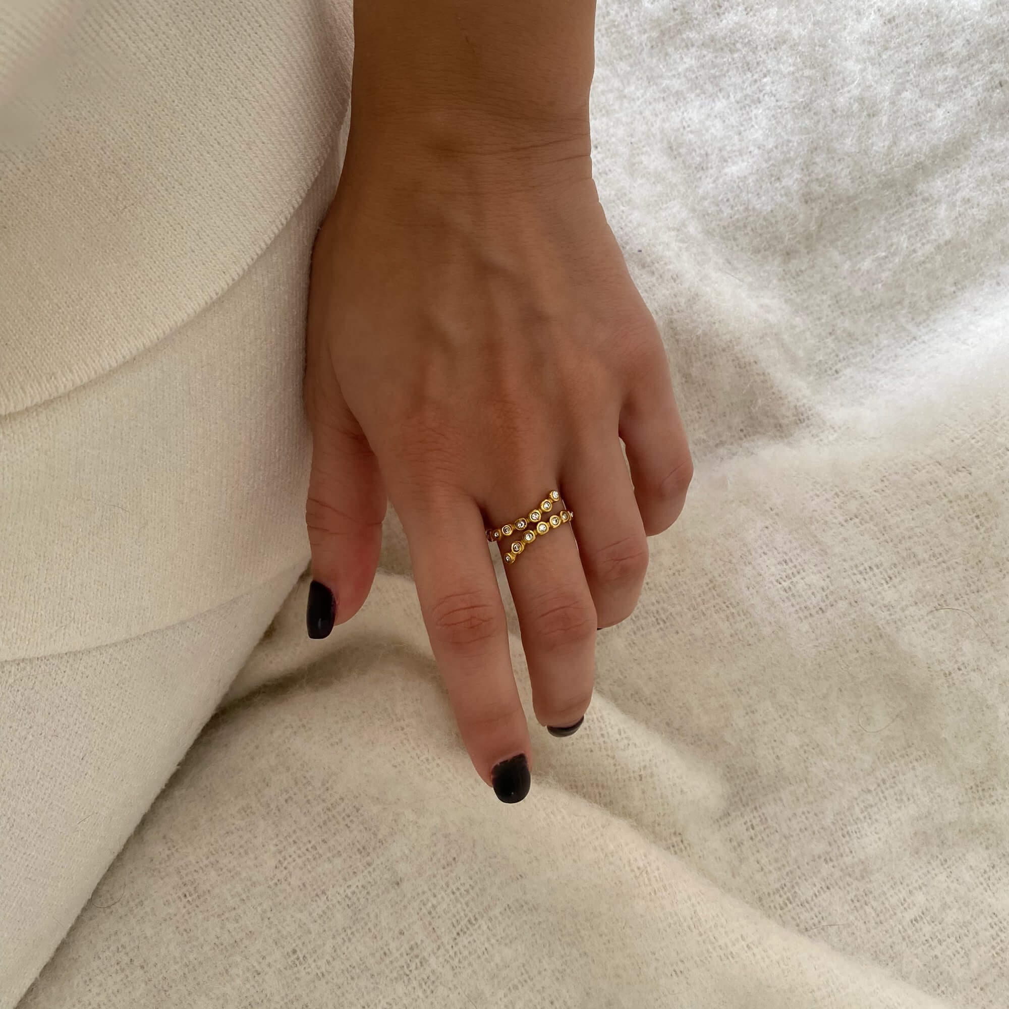 Styled photo of the KazzyR zircon bezel wrap ring by Kampy Designs, paired with layered jewelry for a sleek and elevated look.