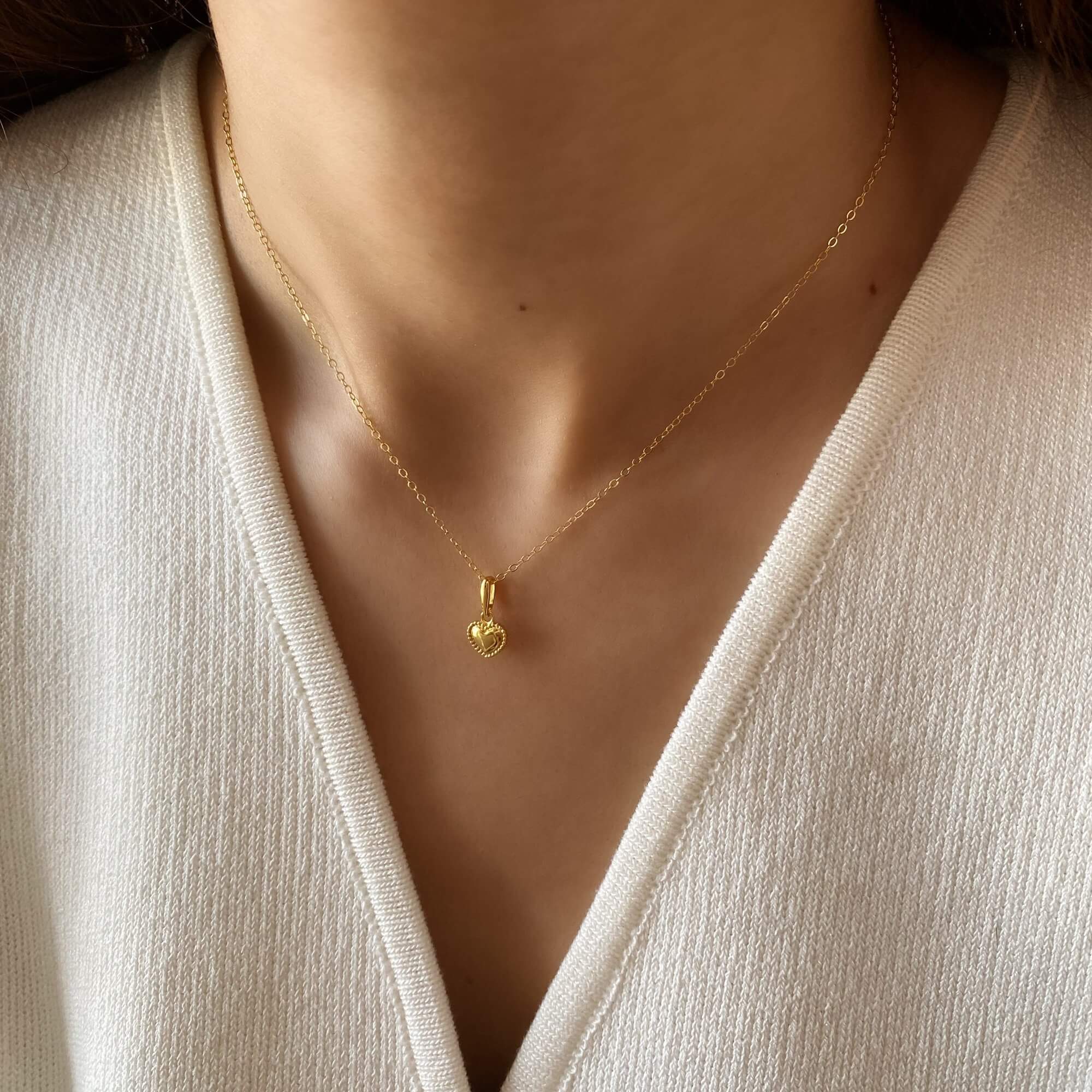 Close-up of the KahiraN 14K gold-plated tiny heart pendant necklace by Kampy Designs, showcasing its delicate heart charm and fine gold chain.