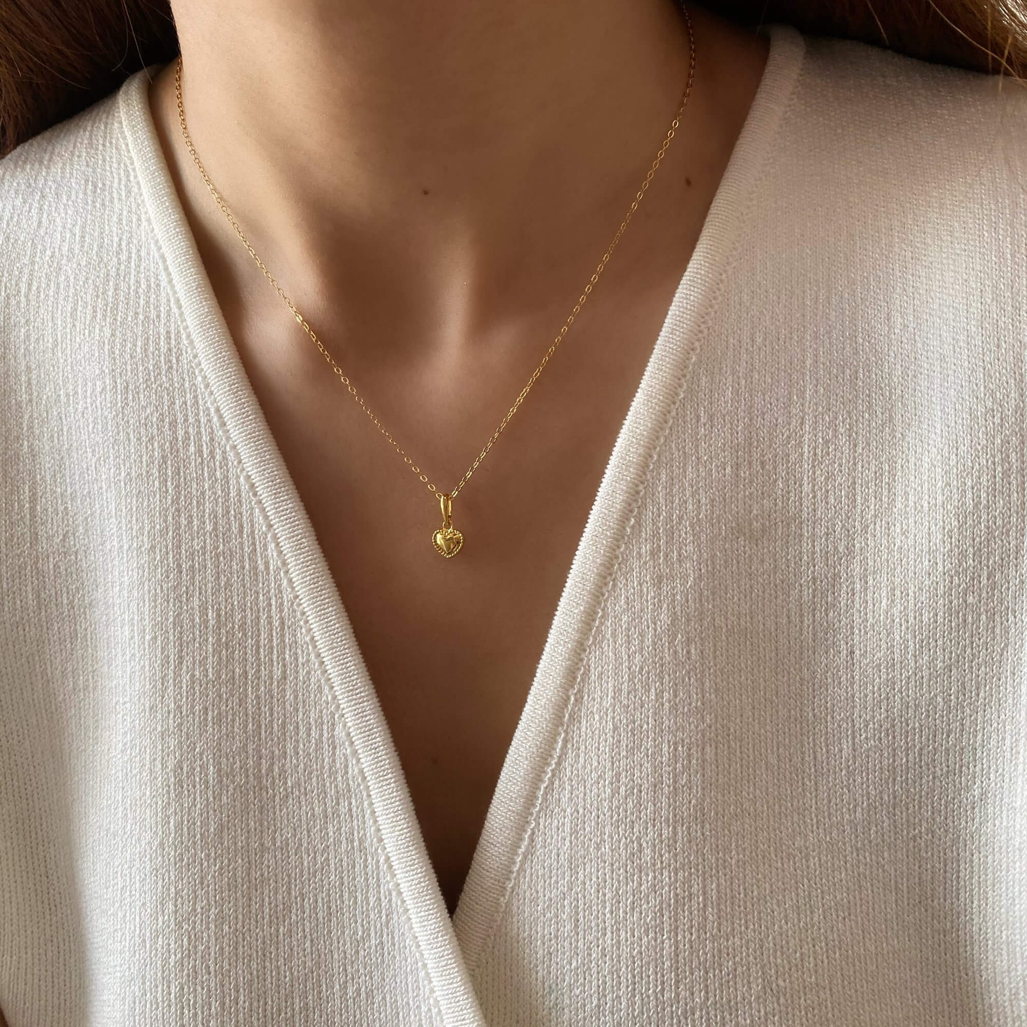 Close-up of the KahiraN 14K gold-plated tiny heart pendant necklace by Kampy Designs, worn on a model, emphasizing its elegant and dainty design.