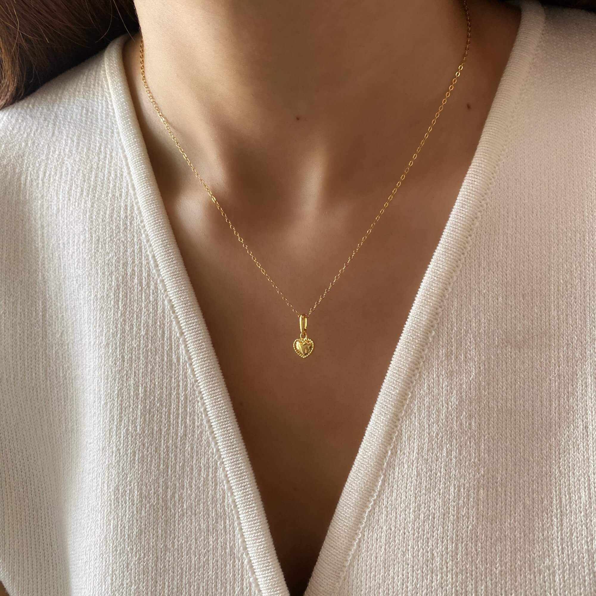 The KahiraN 14K gold-plated tiny heart pendant necklace by Kampy Designs, worn to showcase its delicate and feminine appeal.