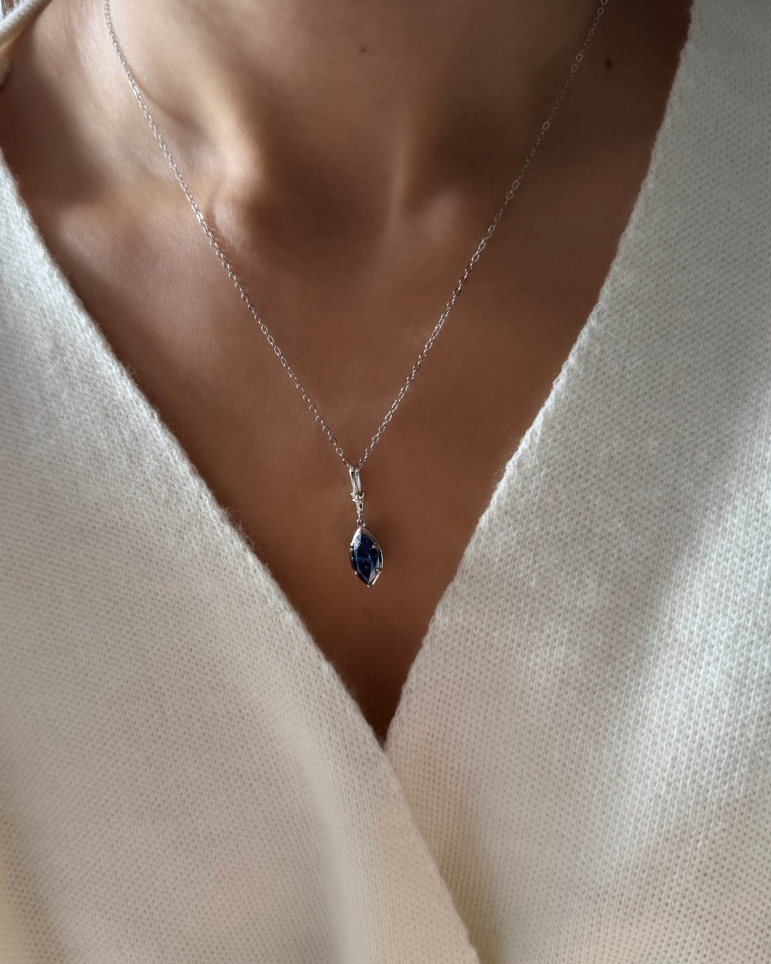 Marquise-cut midnight blue moissanite necklace highlighting elongated neckline and collarbone on model.