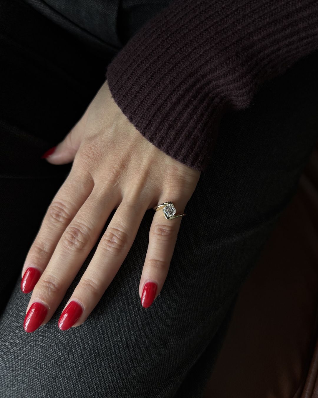 Asscher cut moissanite pinky ring worn on hand with red nails and a sleek minimalist aesthetic