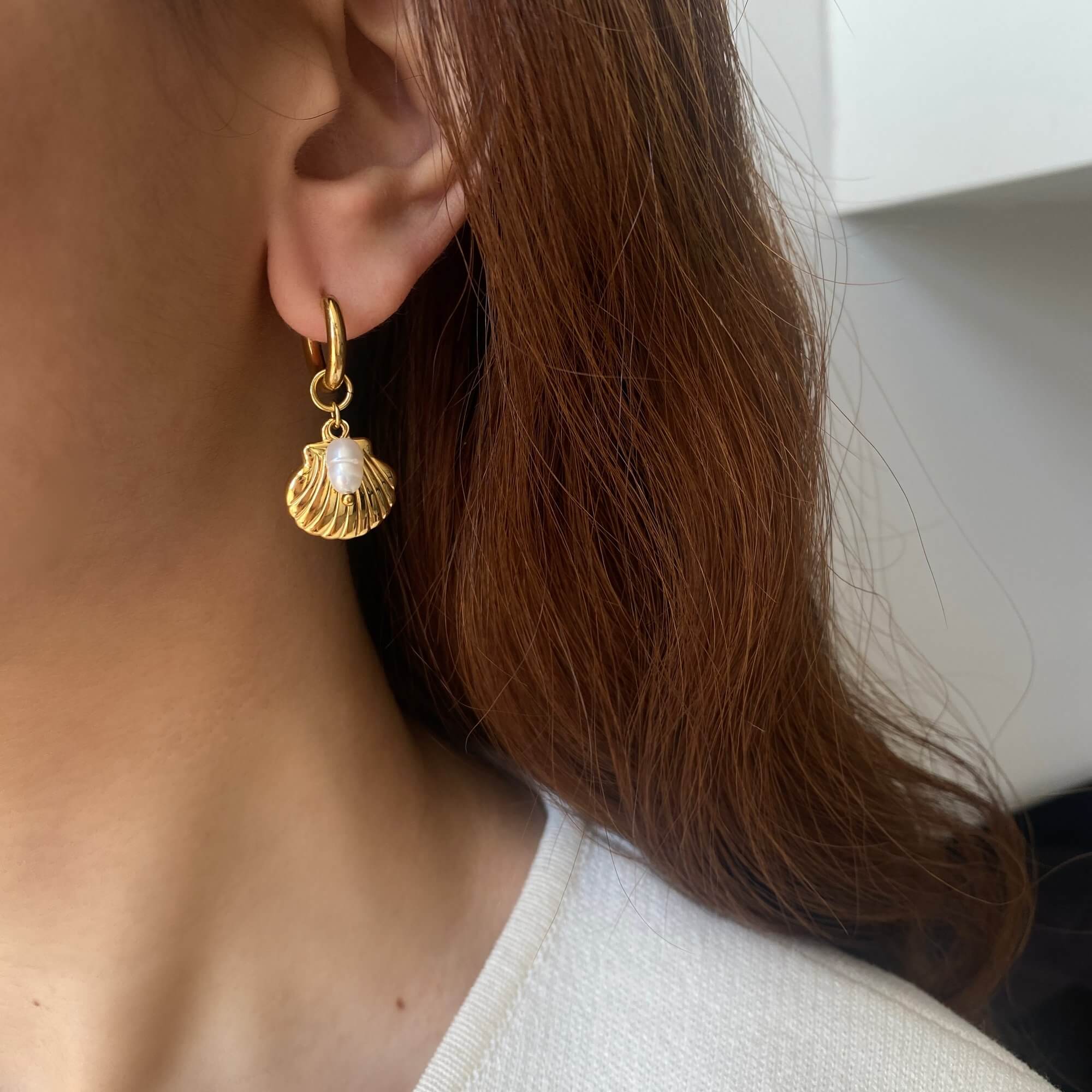 KlammyE clam hoop earring by Kampy Designs, styled on model’s ear for a clean view of its shell-inspired shape and elegance.