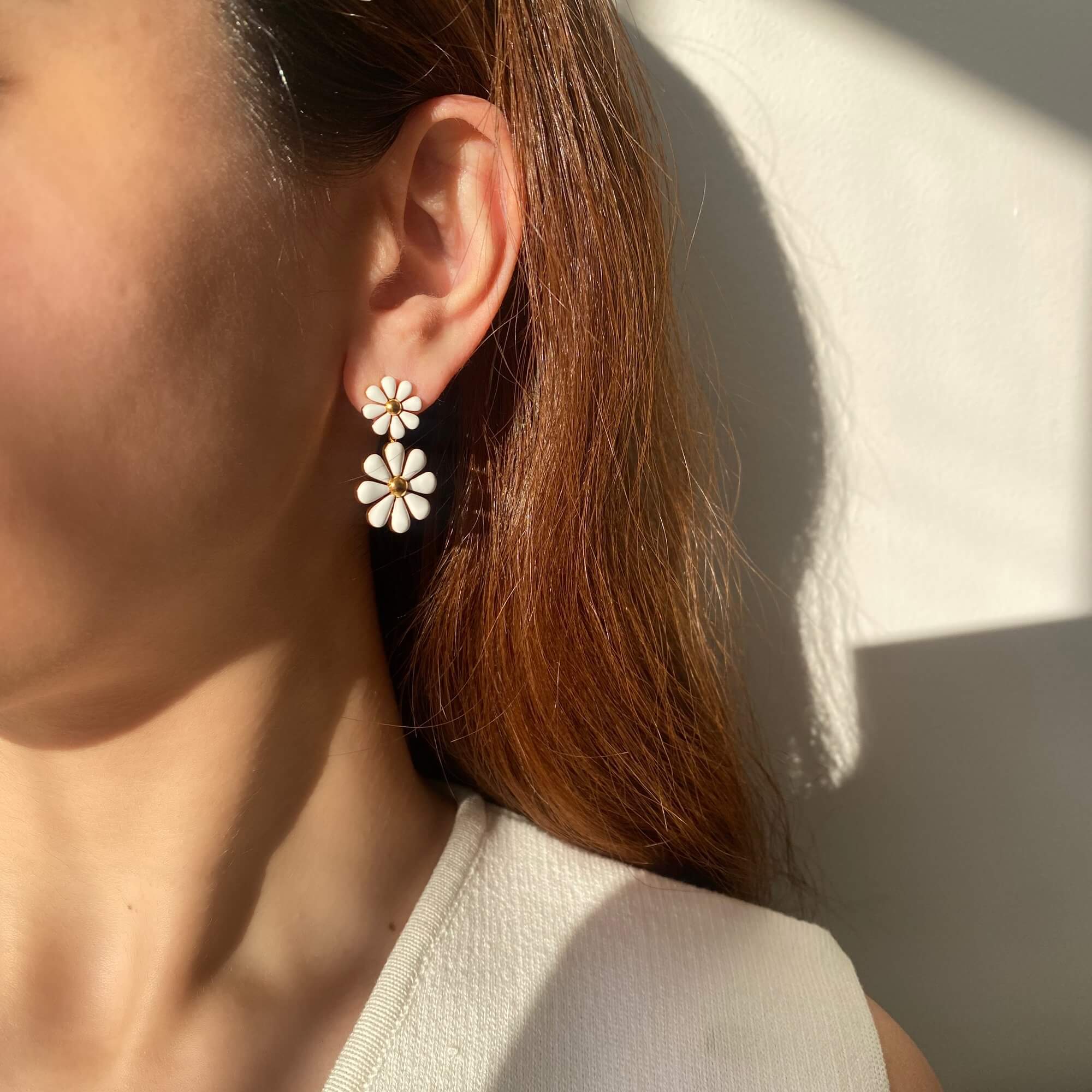 Front-facing view of the KendyR daisy drop earrings by Kampy Designs, worn on model's ear to show off the full floral silhouette.
